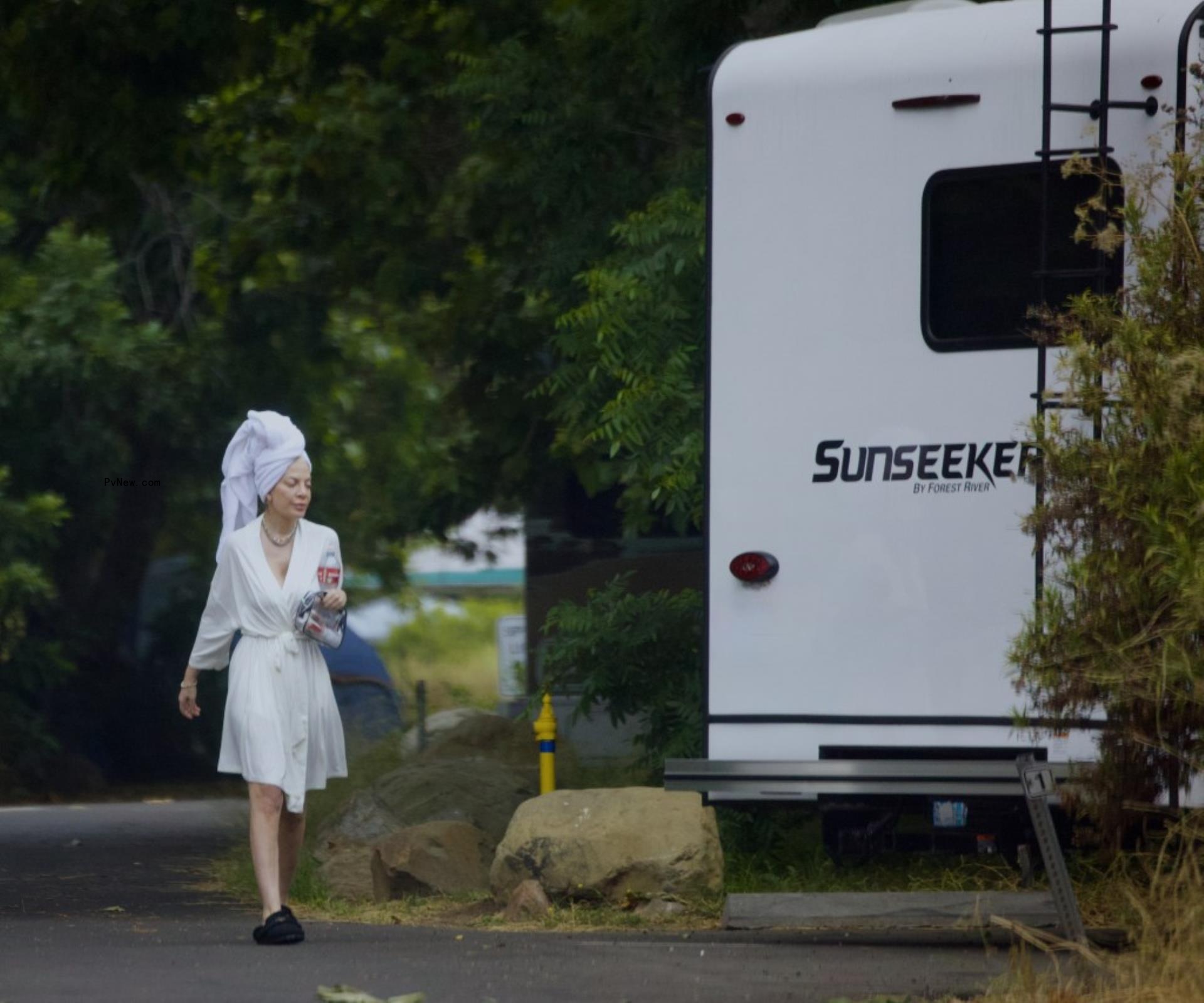 Tori Spelling in a robe outside of her RV. 