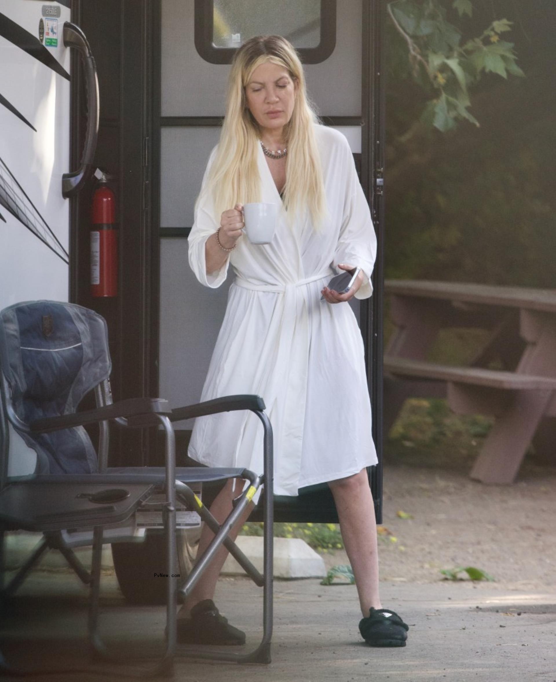 Tori Spelling in a robe outside of her RV. 