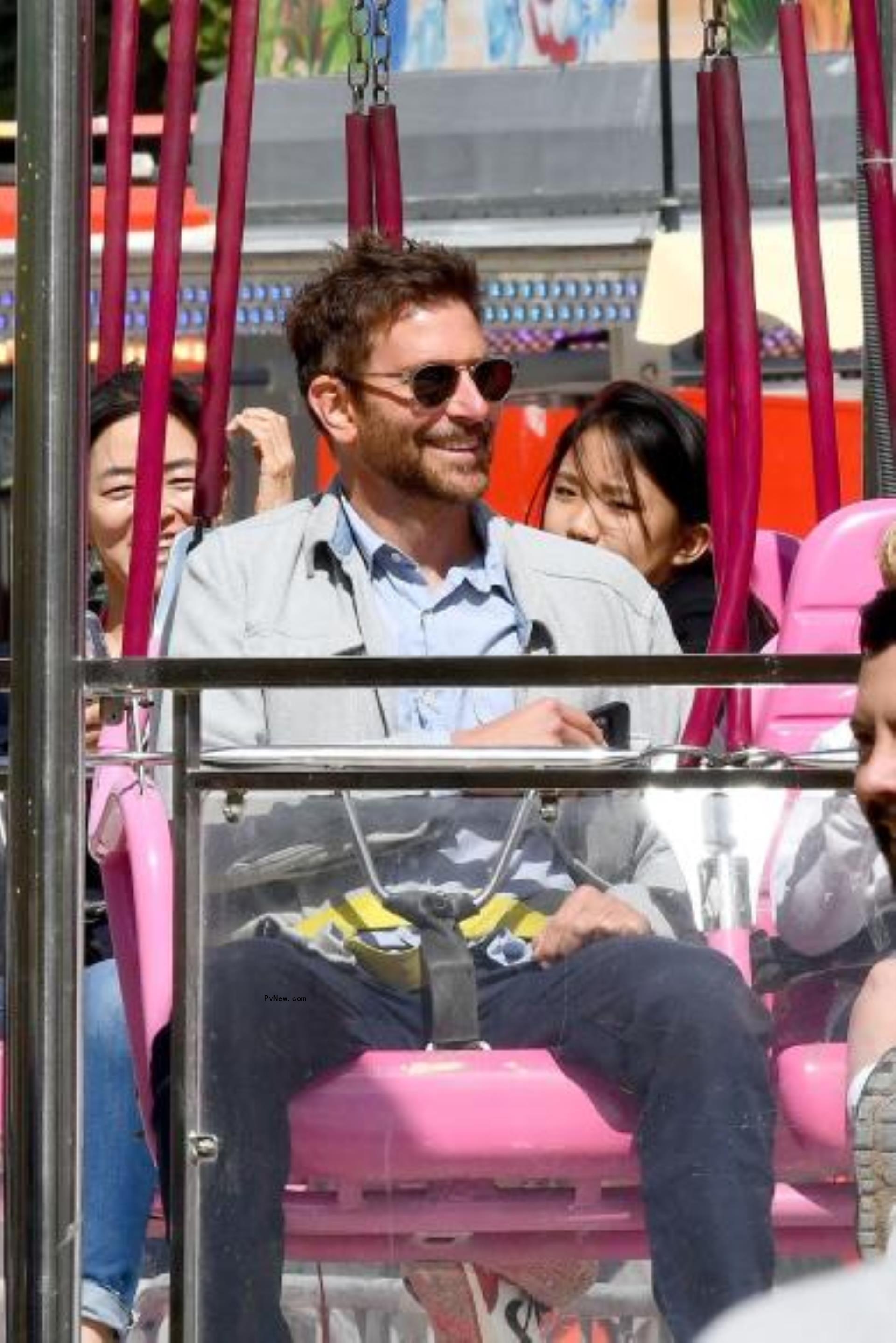 Bradley Cooper riding swings at the fair