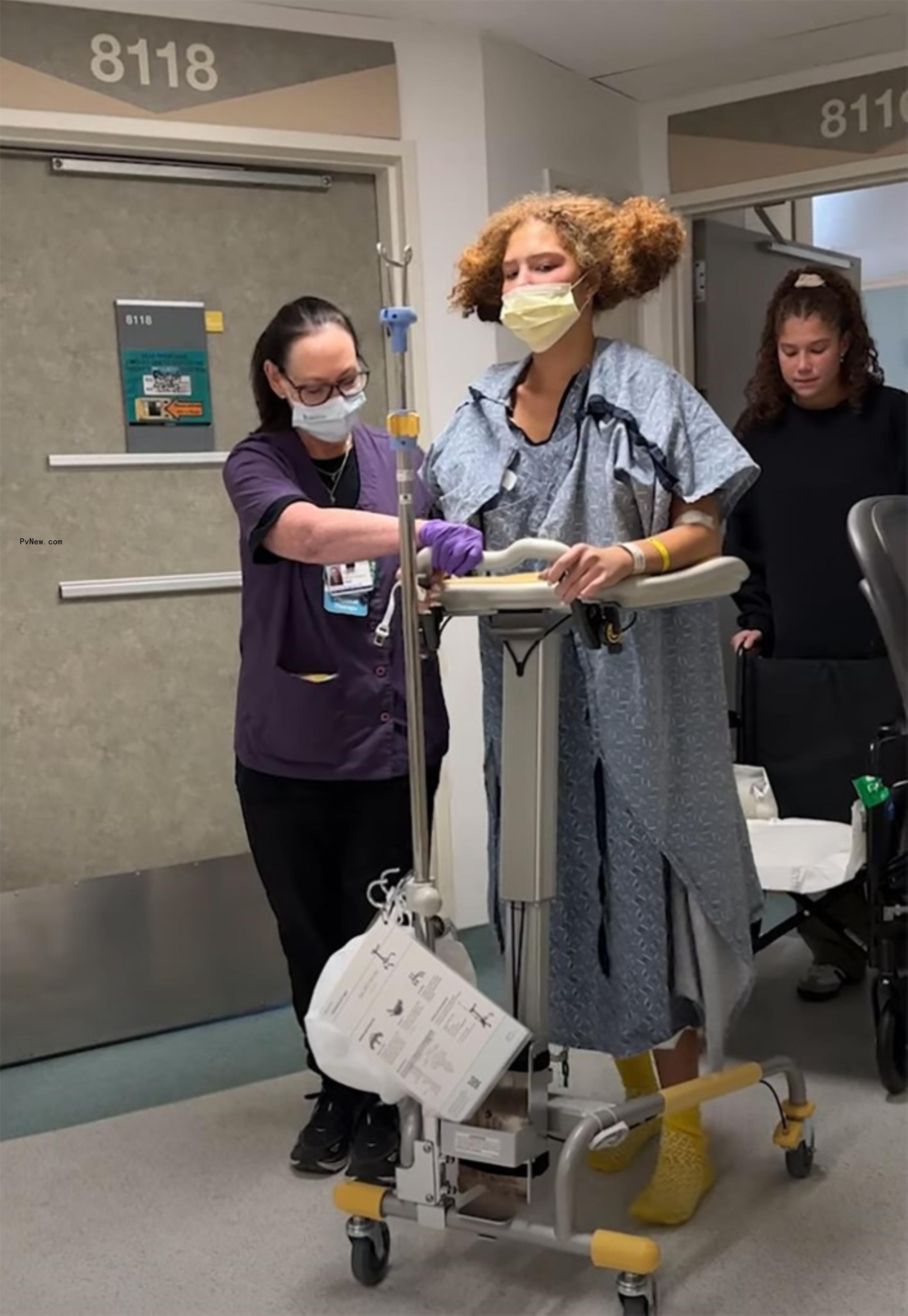 isabella strahan walking with a walker and assistance from nurses