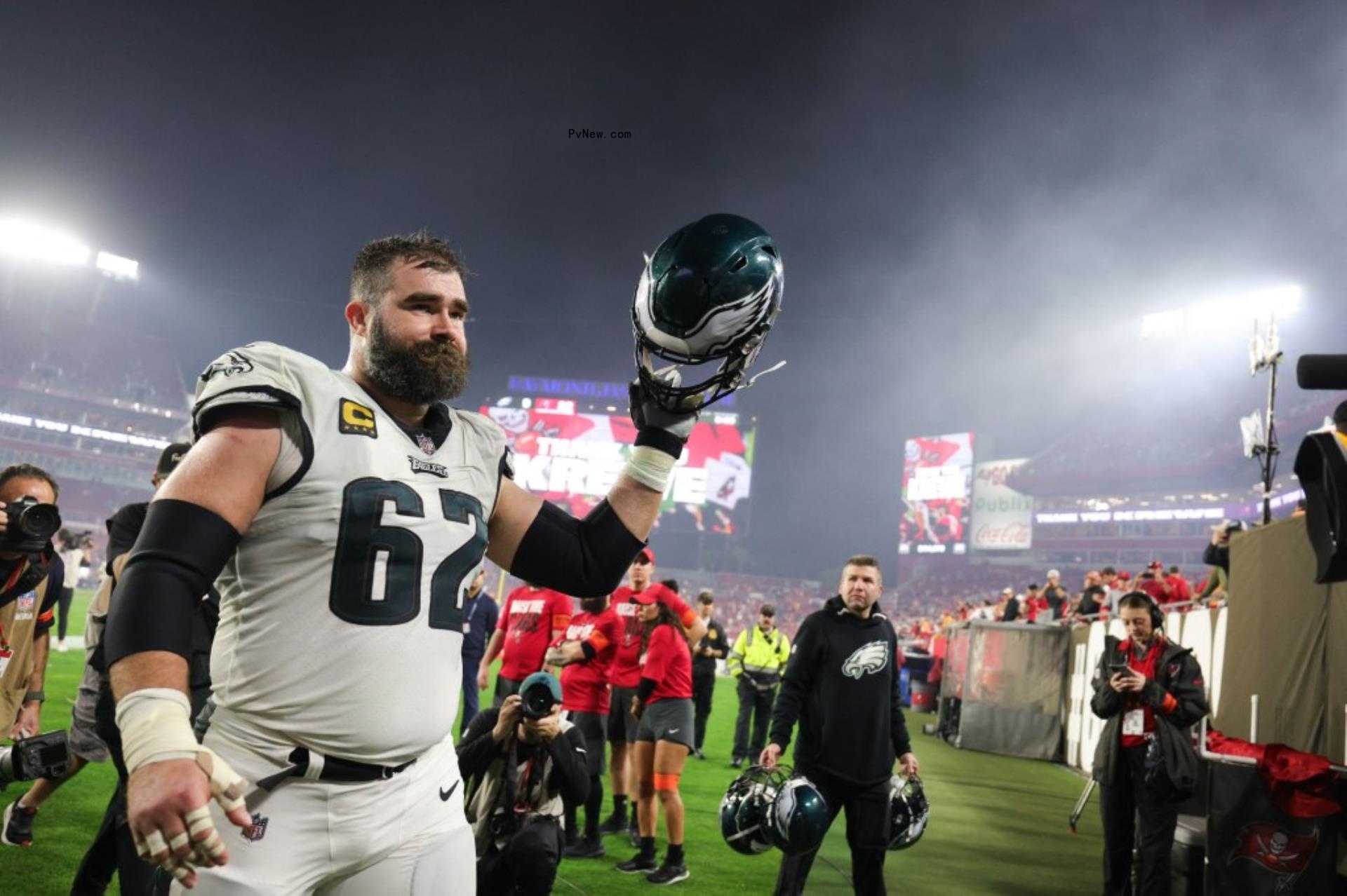 Jason Kelce lifting his football helmet on the field.
