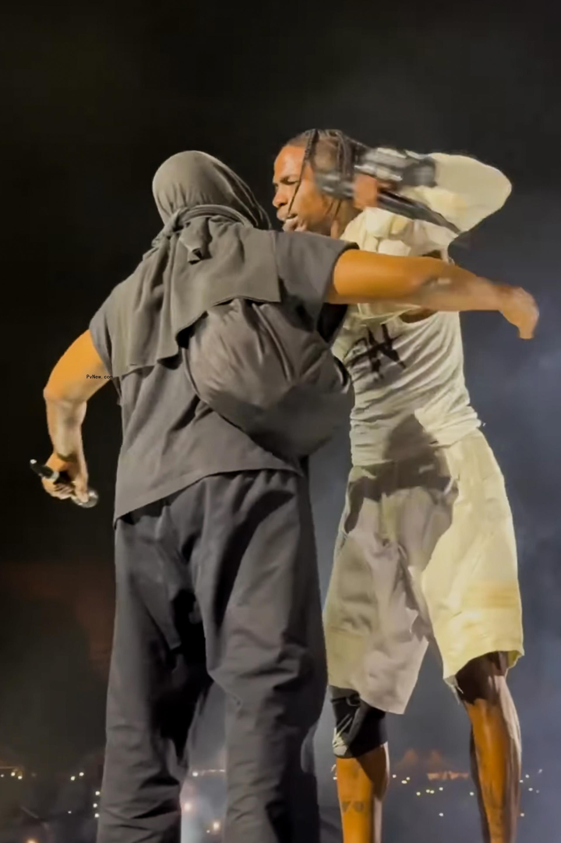 Travis Scott and Kanye West hugging onstage.