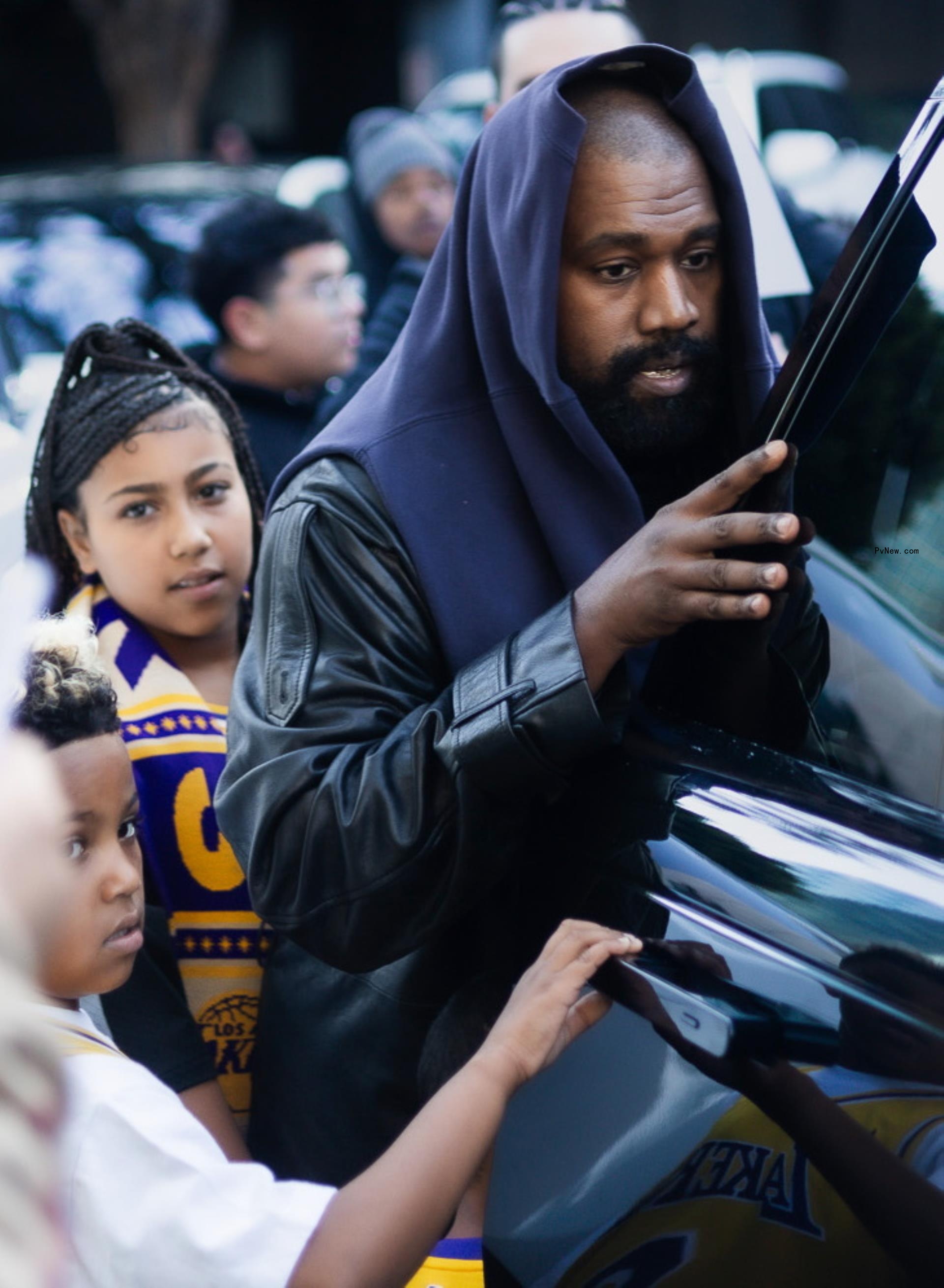 kanye west getting into a car with north west and saint west