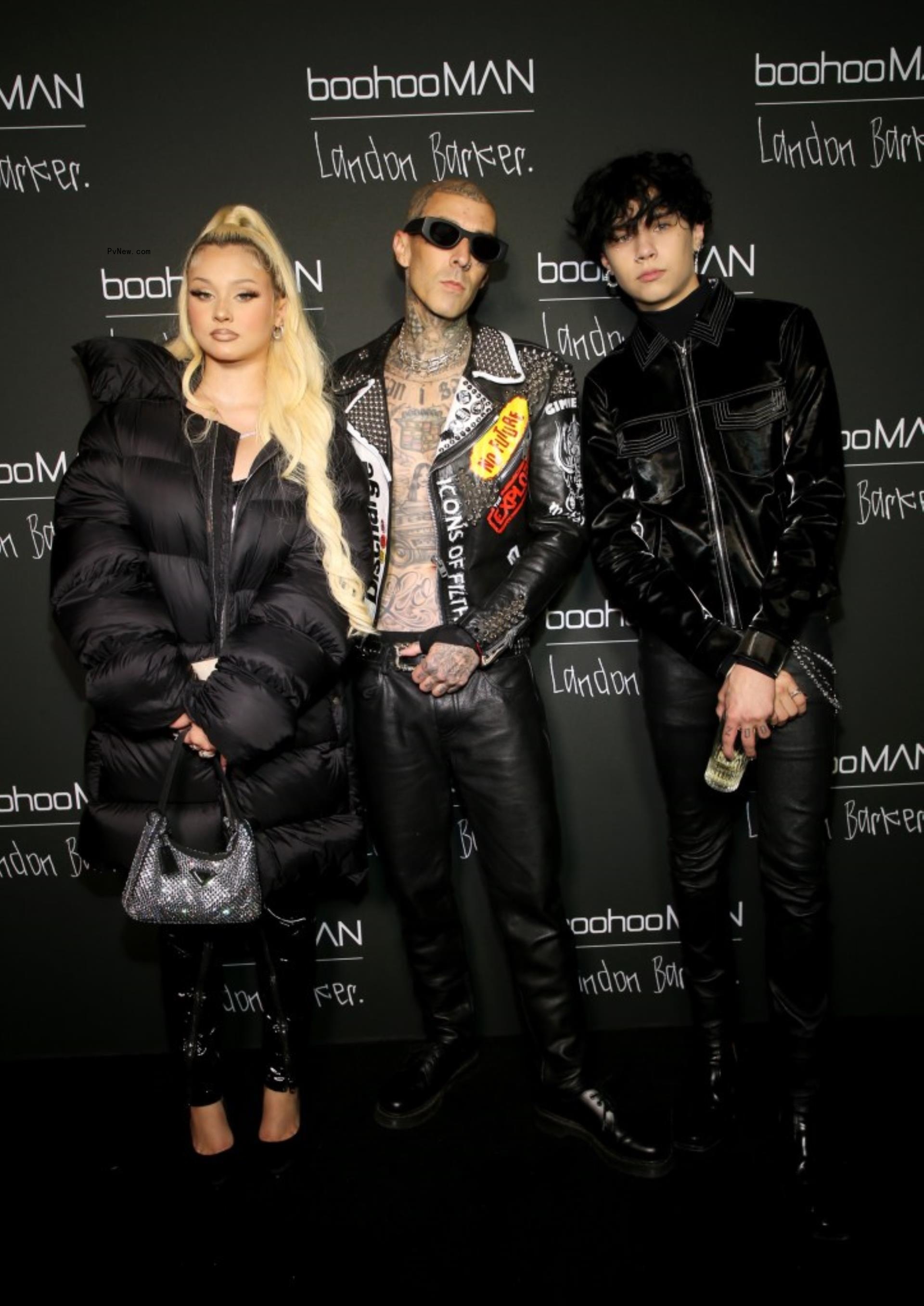 Travis Barker posing with two of his children Landon and Alabama all wearing black.