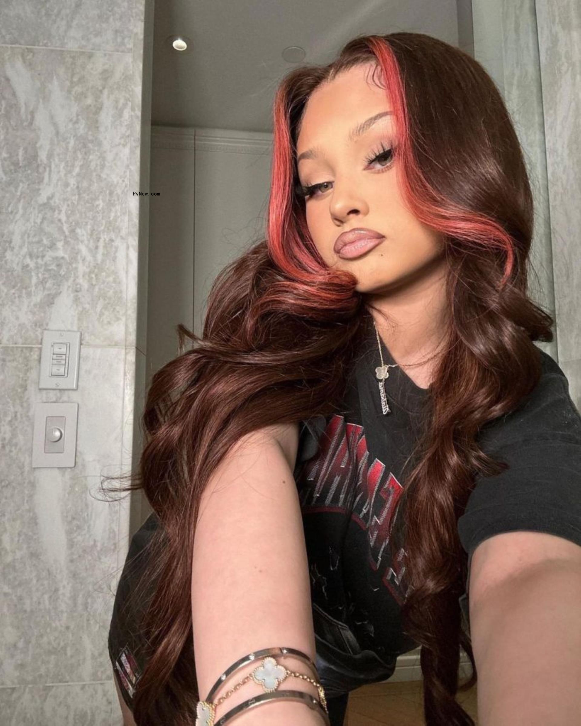 Alabama posing with a red lace front wig.