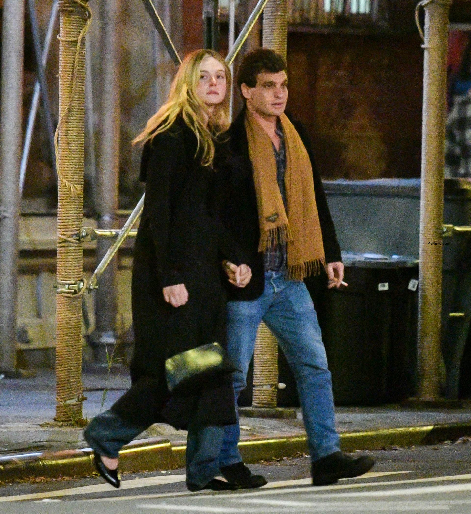 Elle Fanning and Gus Wenner holding hands.