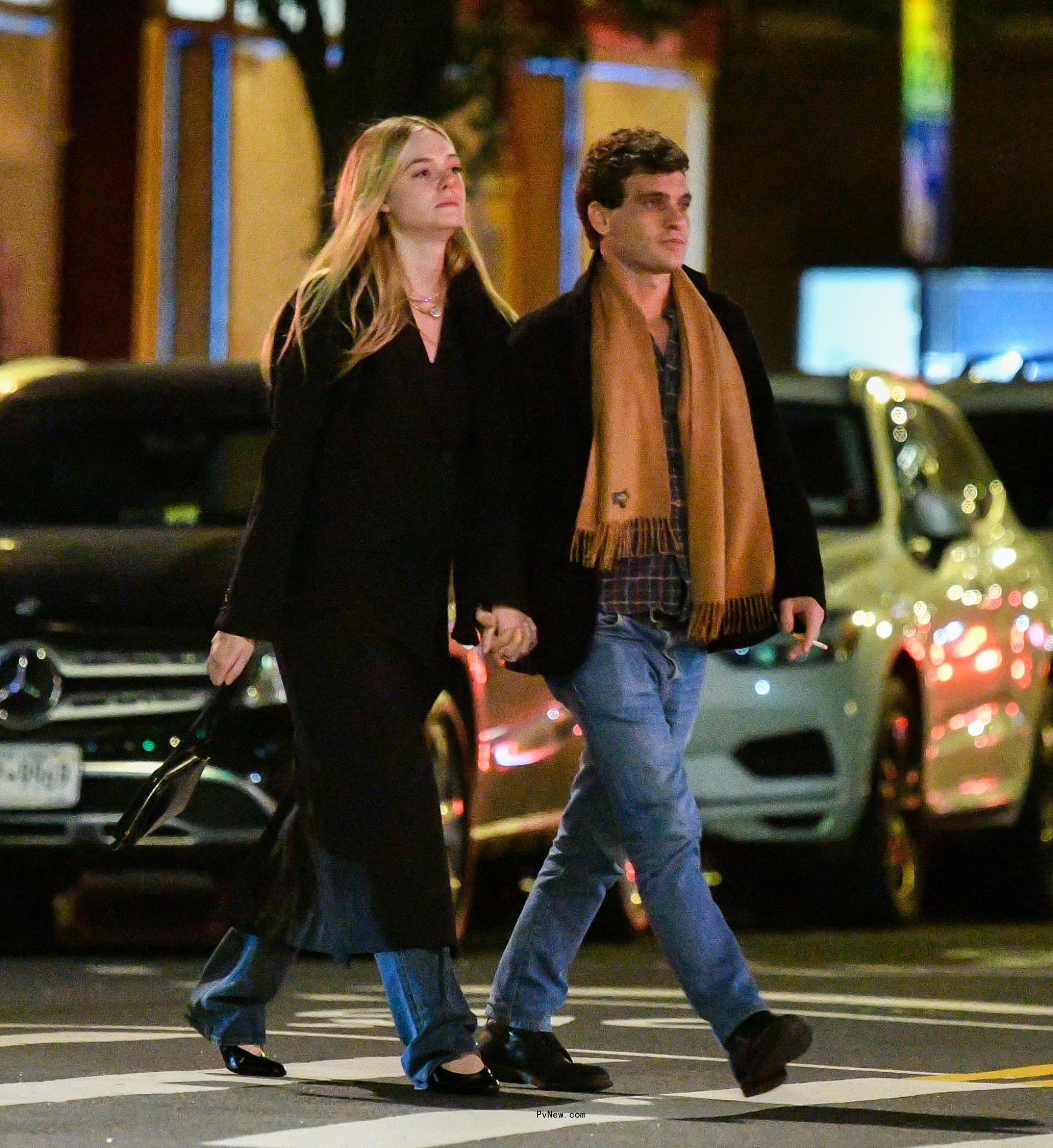 Elle Fanning and Gus Wenner holding hands.