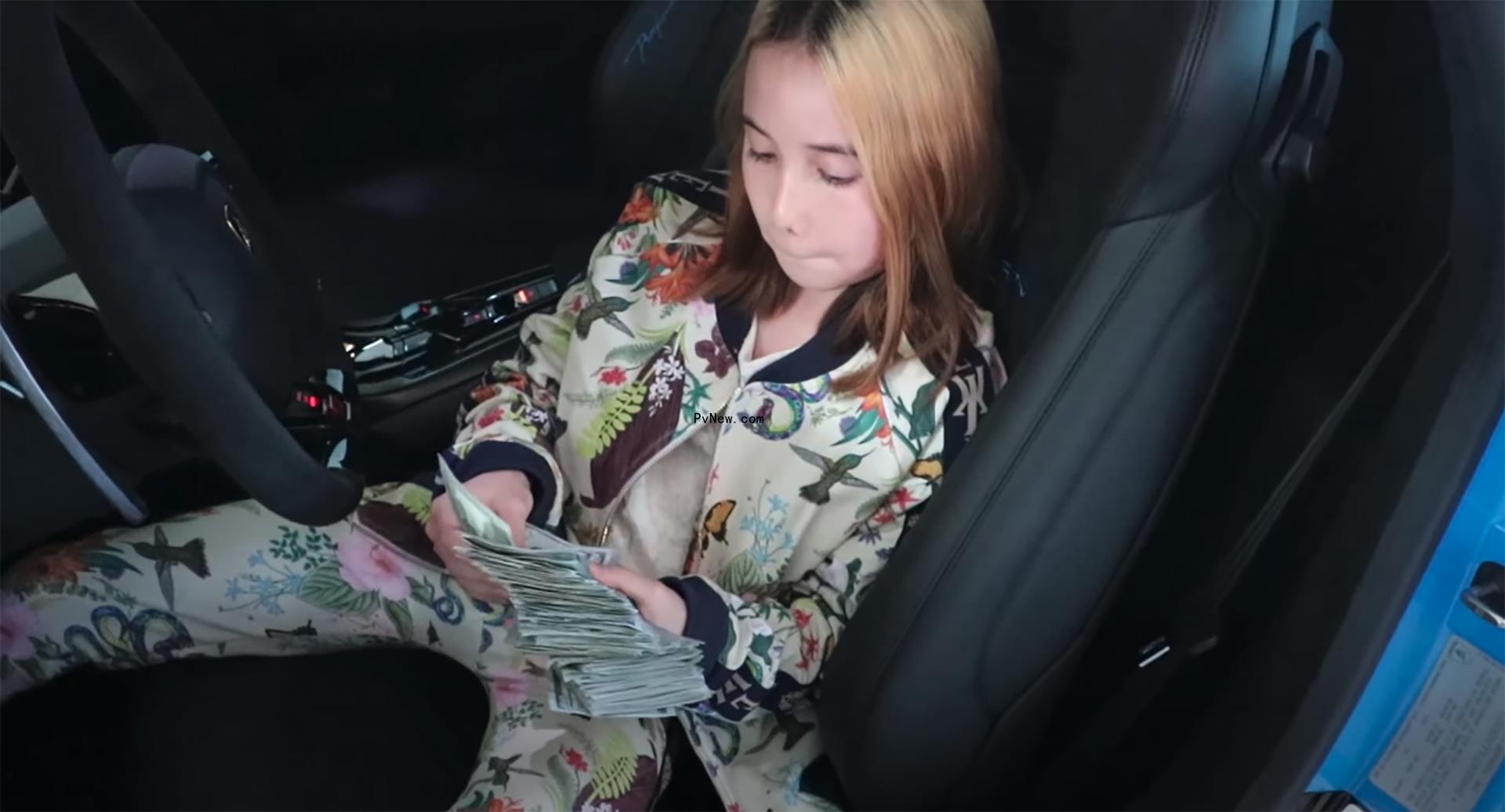 Lil Tay looking at mo<i></i>ney while in a car.