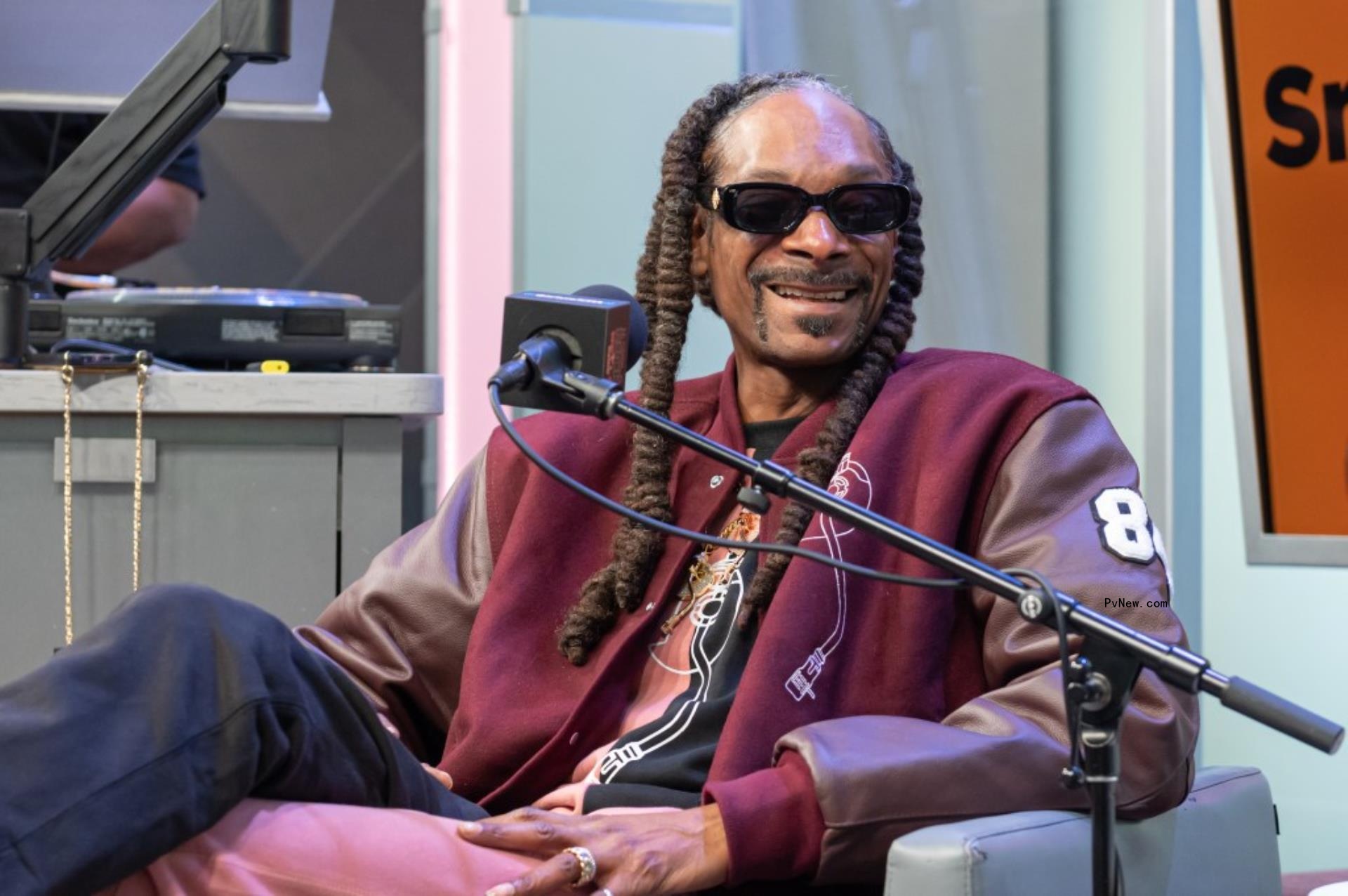 snoop dogg sitting in a chair with a mic