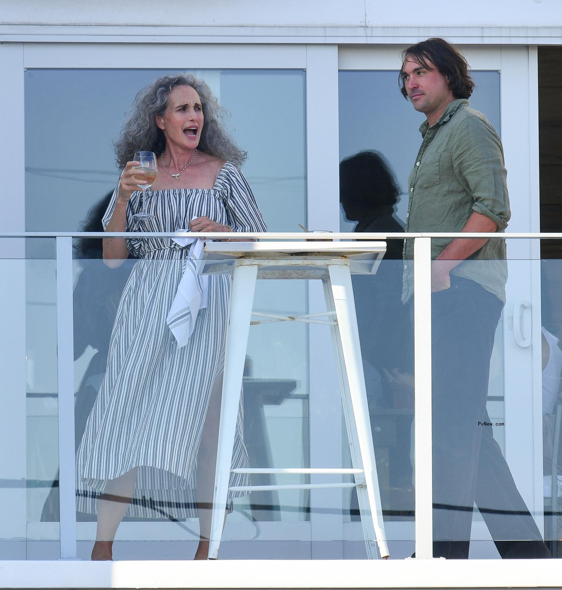 Actress and mother-of-the-bride Andie MacDowell is pictured with her son Justin Qualley on the deck of the rehearsal dinner.