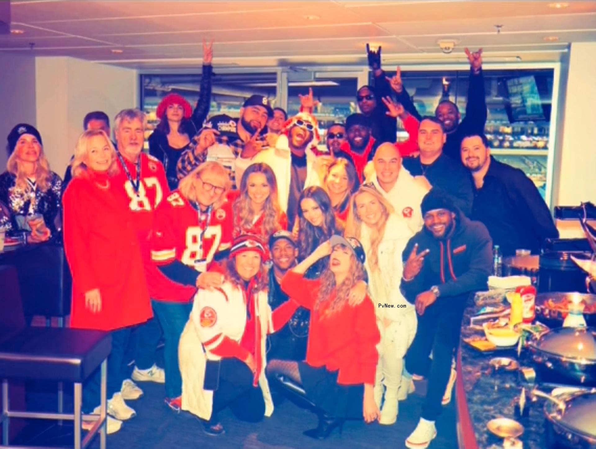Taylor Swift posing with Travis Kelce's family and friends at Chiefs game