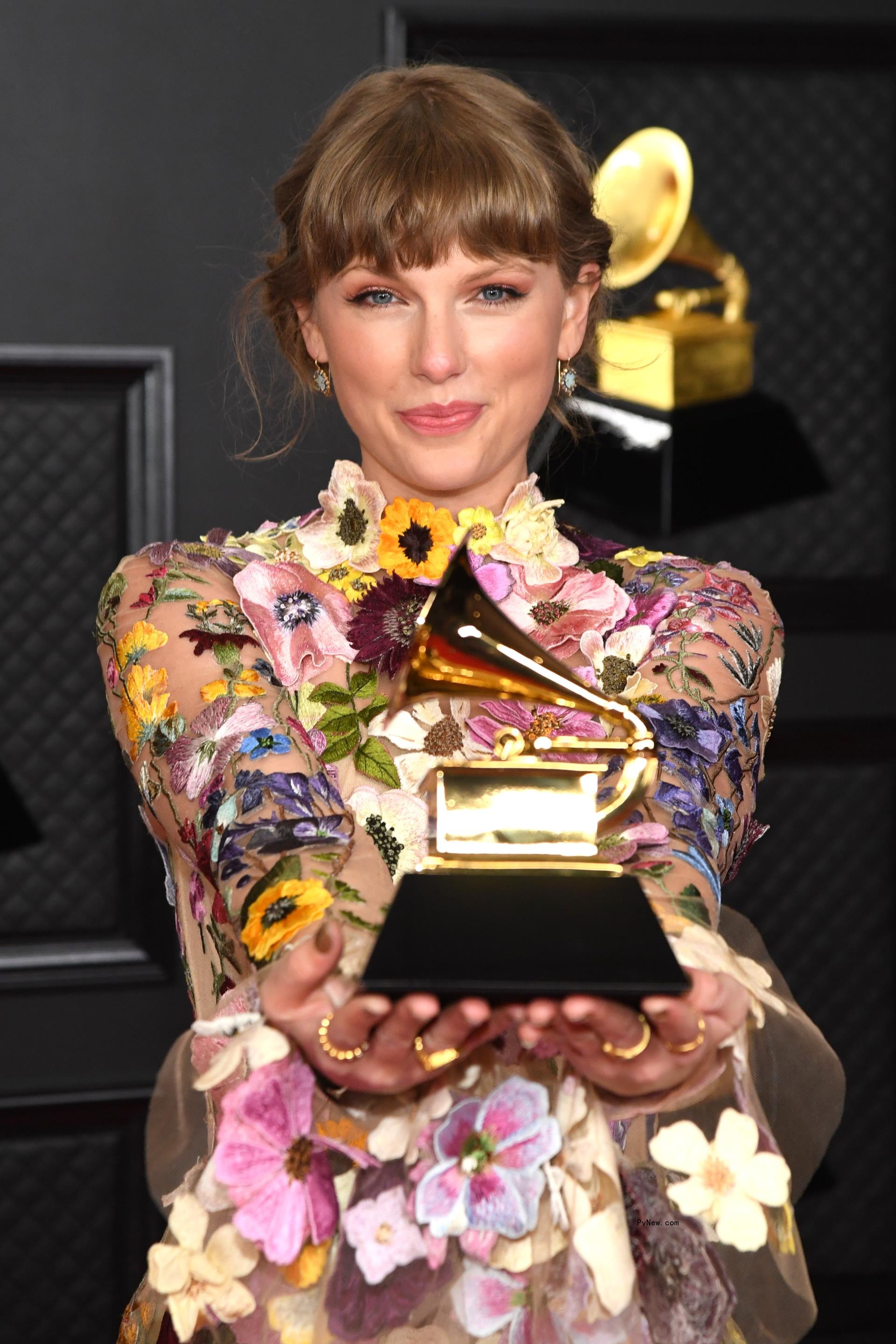 Taylor Swift holding a Grammy award in 2021.