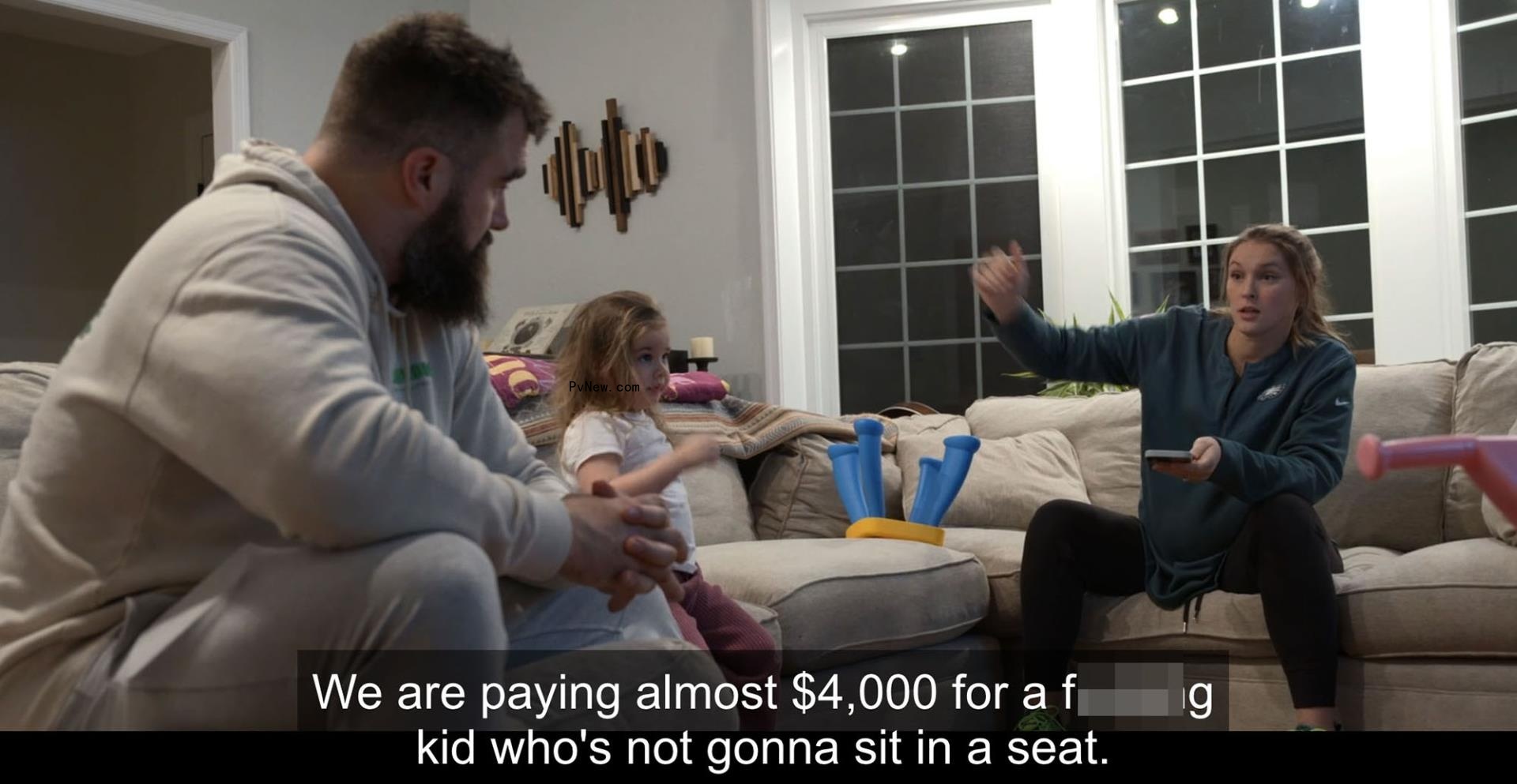 Jason Kelce speaking to Kylie Kelce with their daughter.