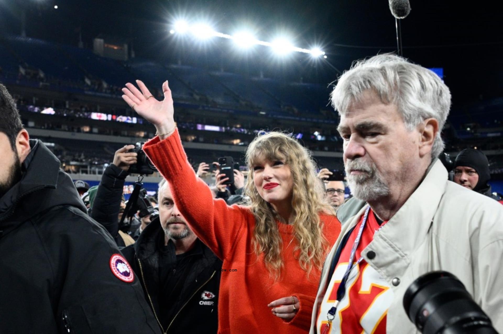 Taylor Swift waves next to Ed Kelce