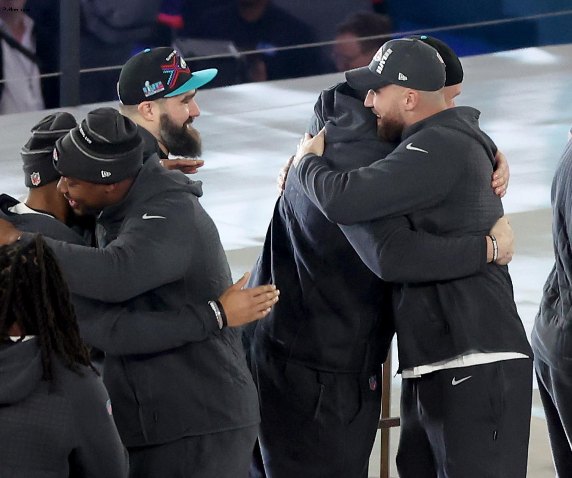 Travis Kelce hugging lane johnson and jason kelce.