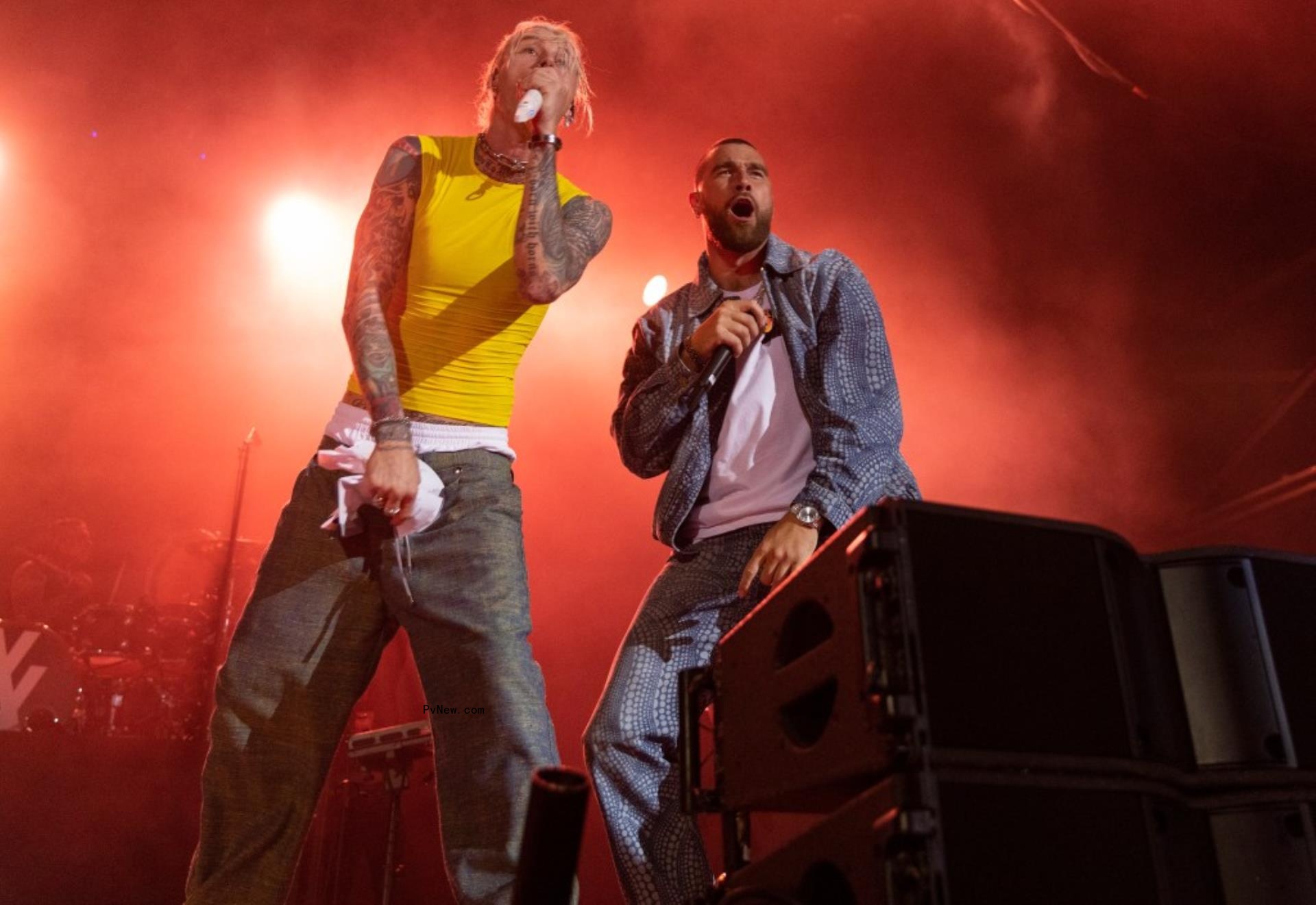 travis kelce performing on stage with machine gun kelly