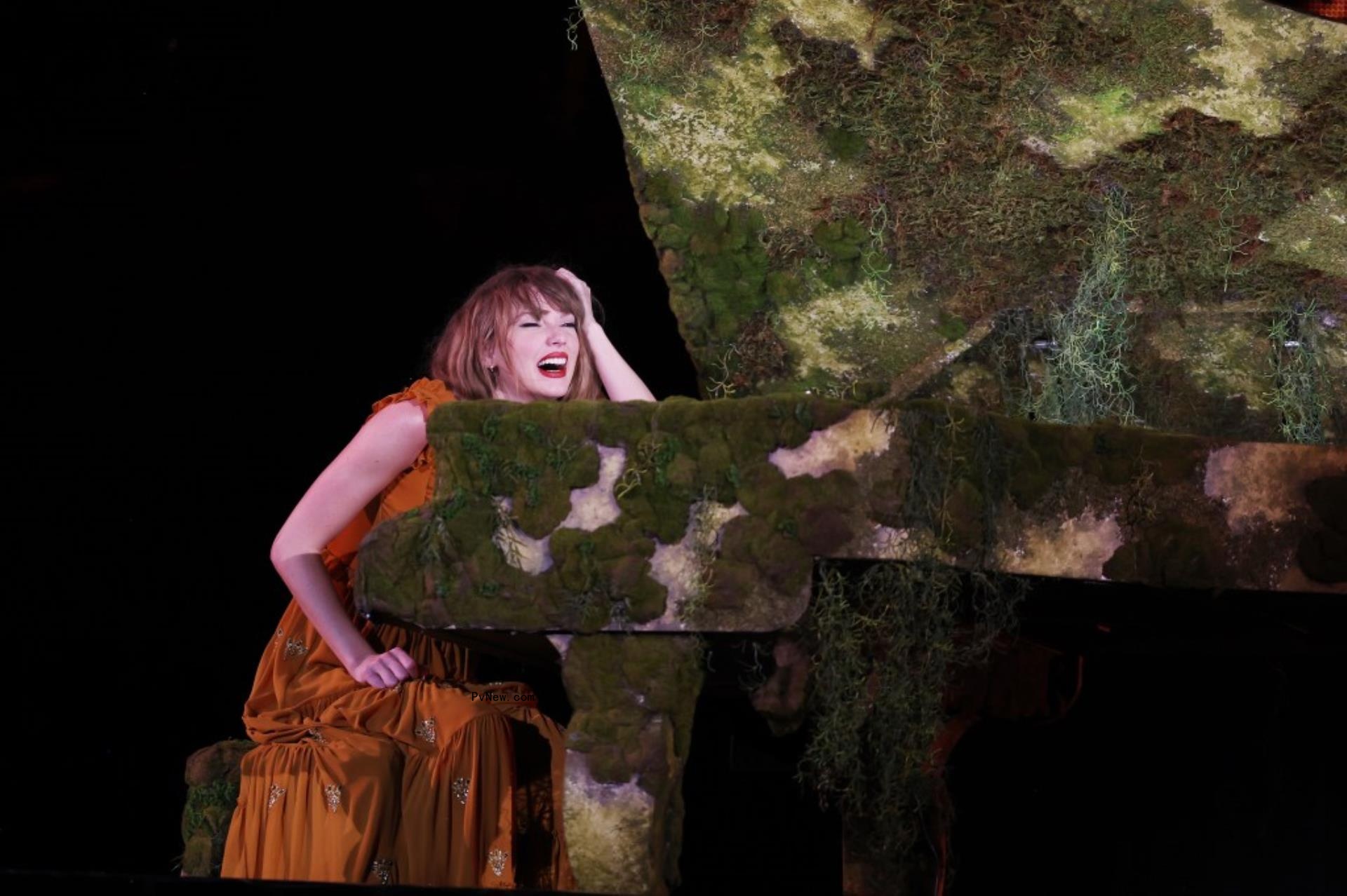 taylor swift performing at moss-covered piano