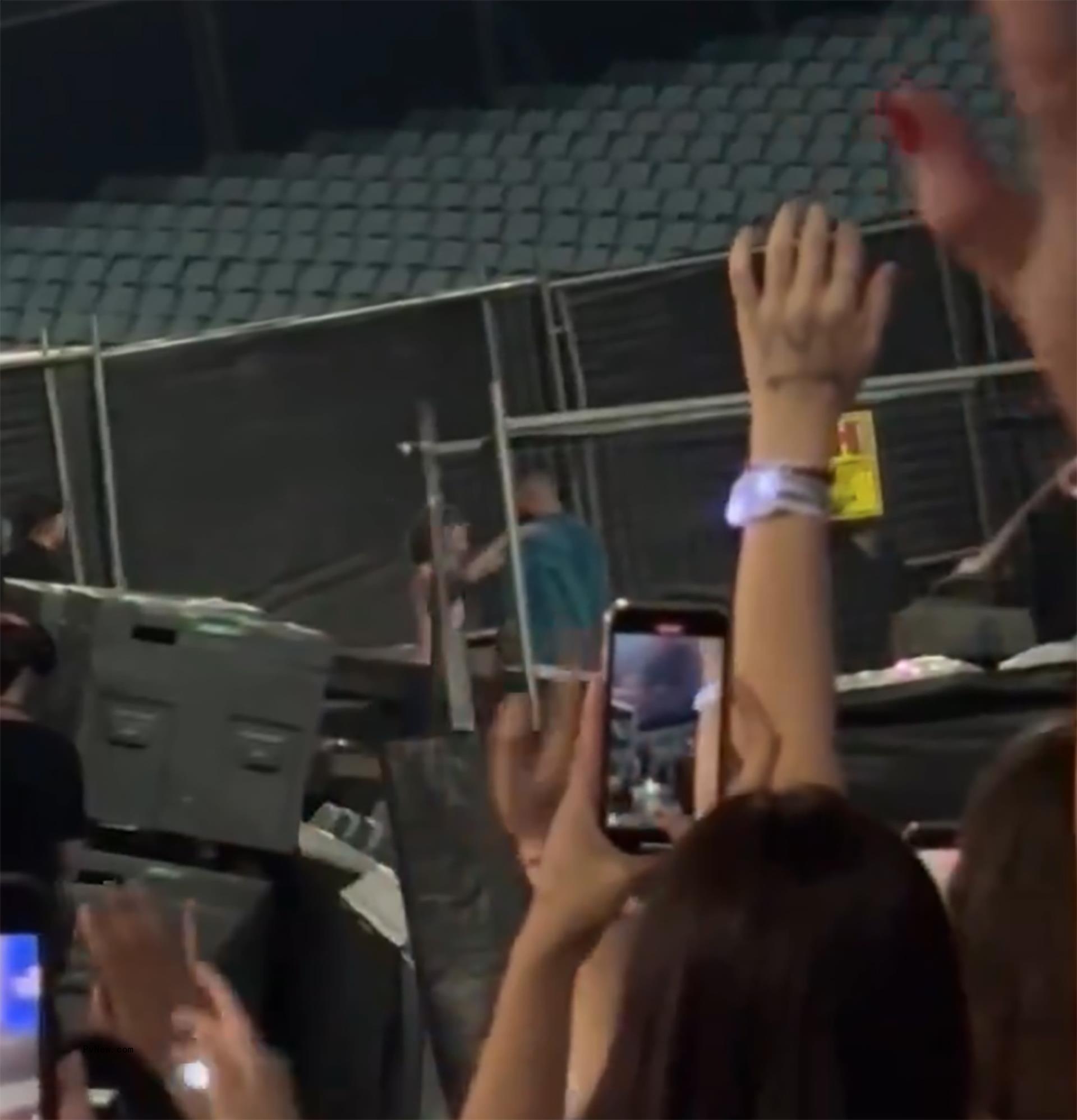 distant shot of people taking photos of taylor swift and travis kelce