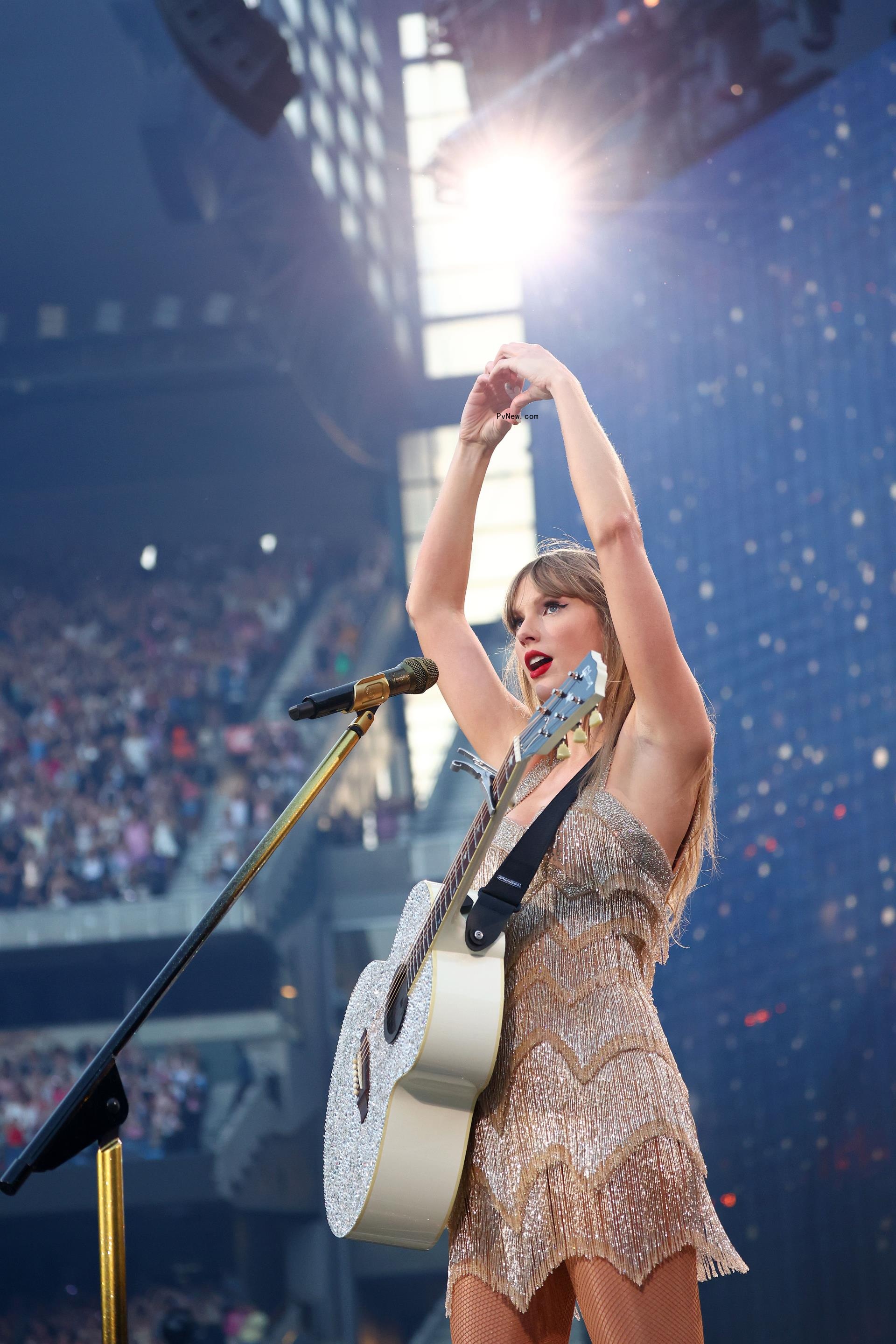 Taylor Swift making a heart shape with her hands while onstage.