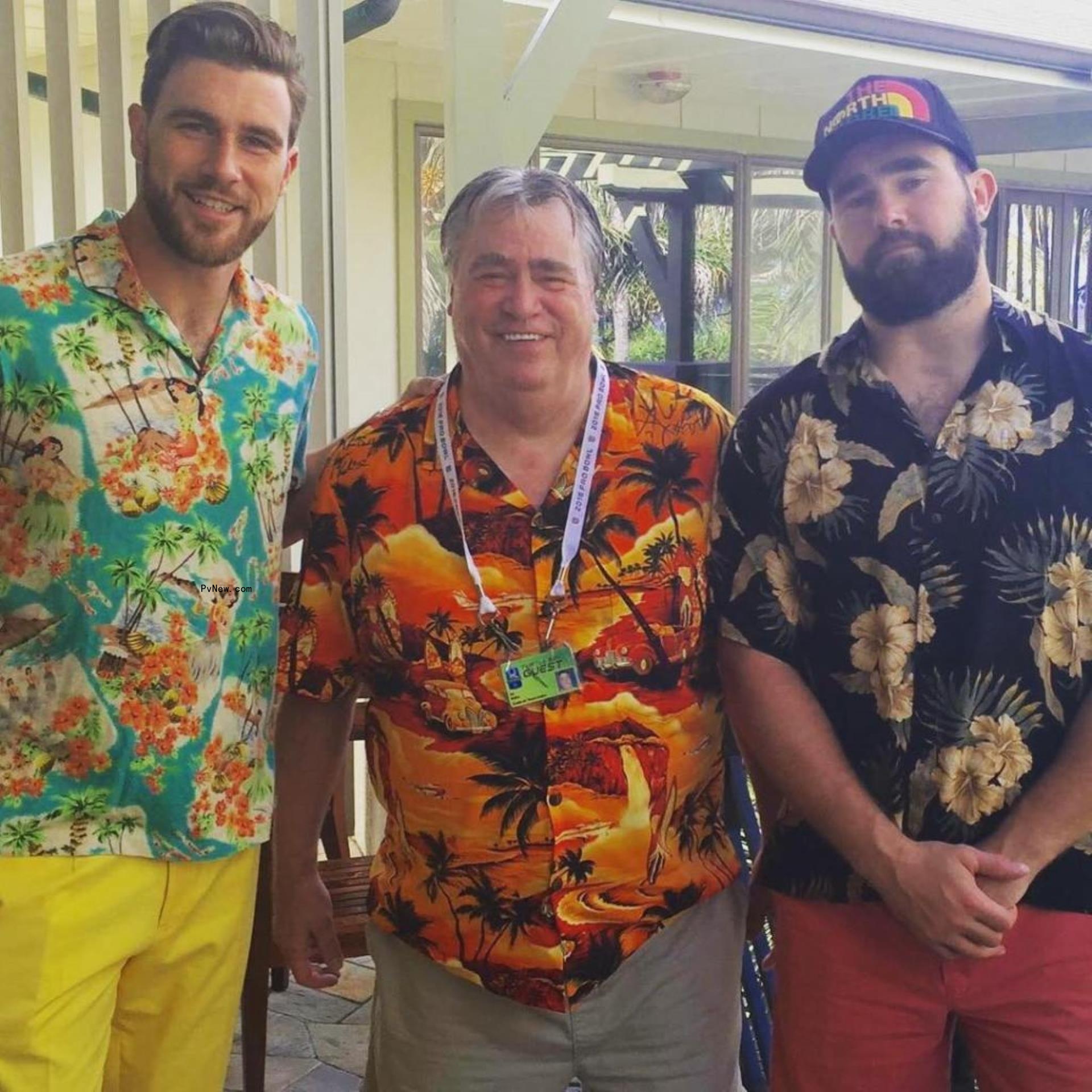 Travis and Jason Kelce pose with their dad in the center. They all wear Hawaiian shirts.