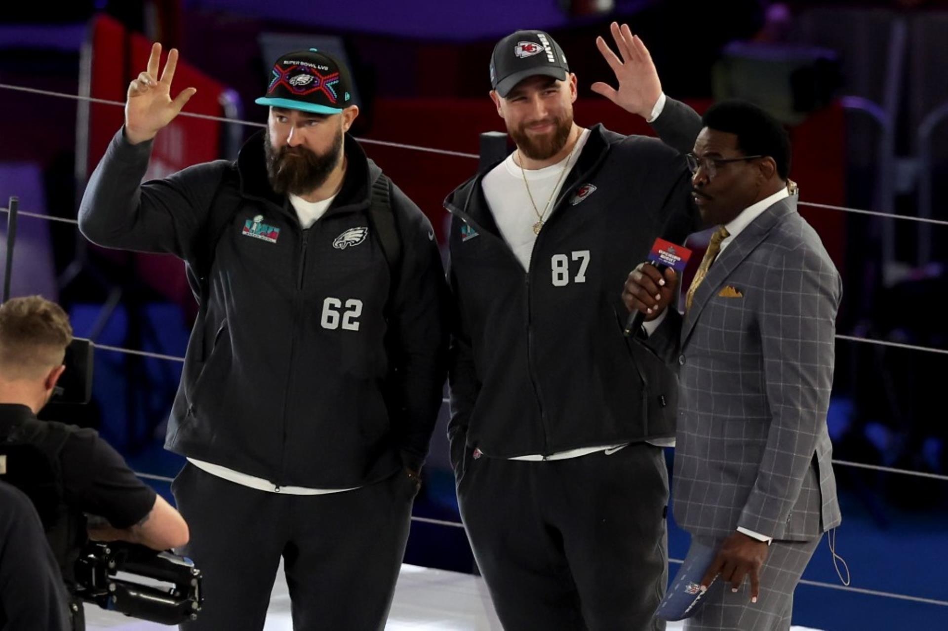 Travis and Jason Kelce wave in matching Super Bowl sweatsuits. 