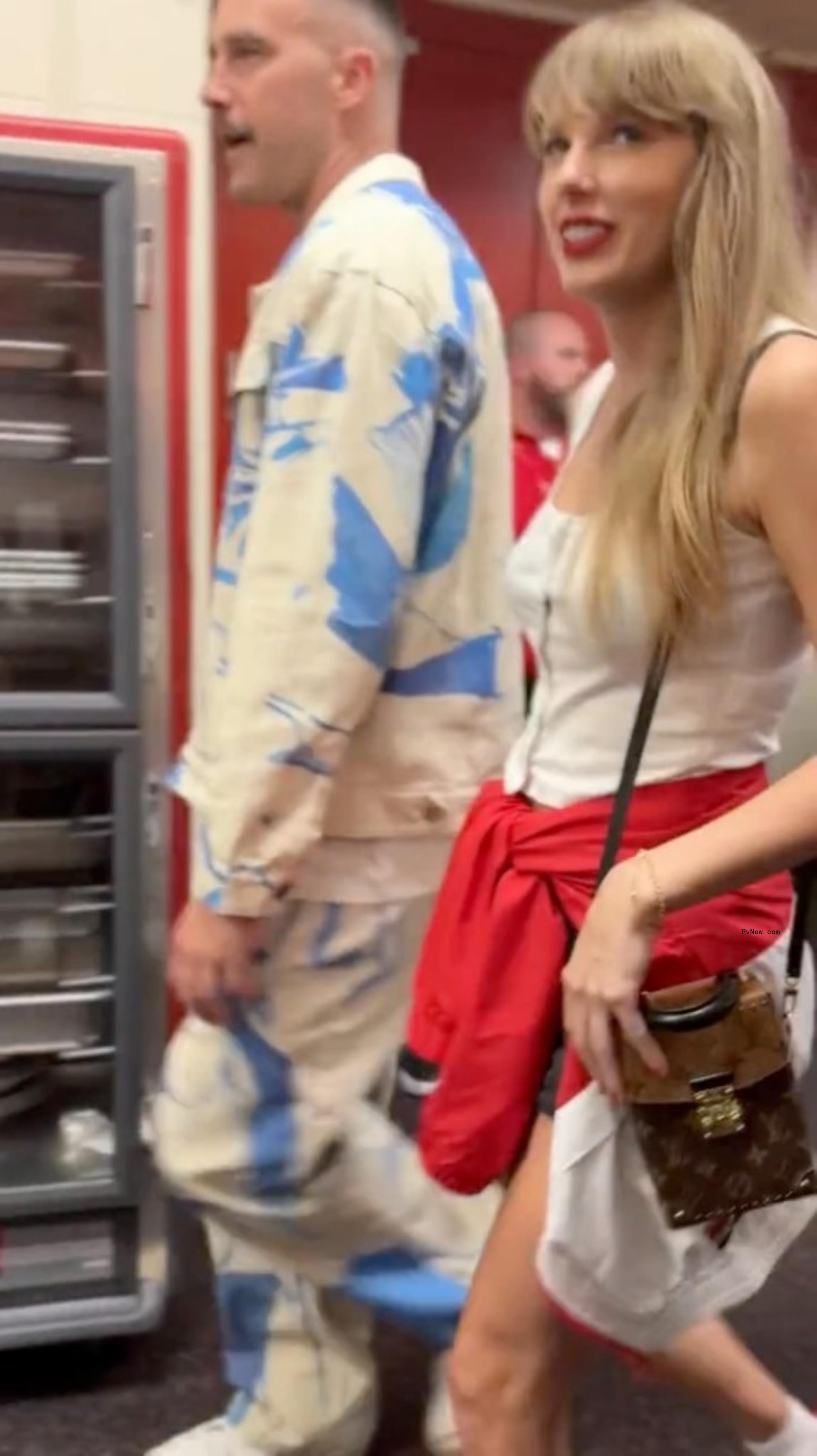 Travis Kelce and Taylor Swift walking together.