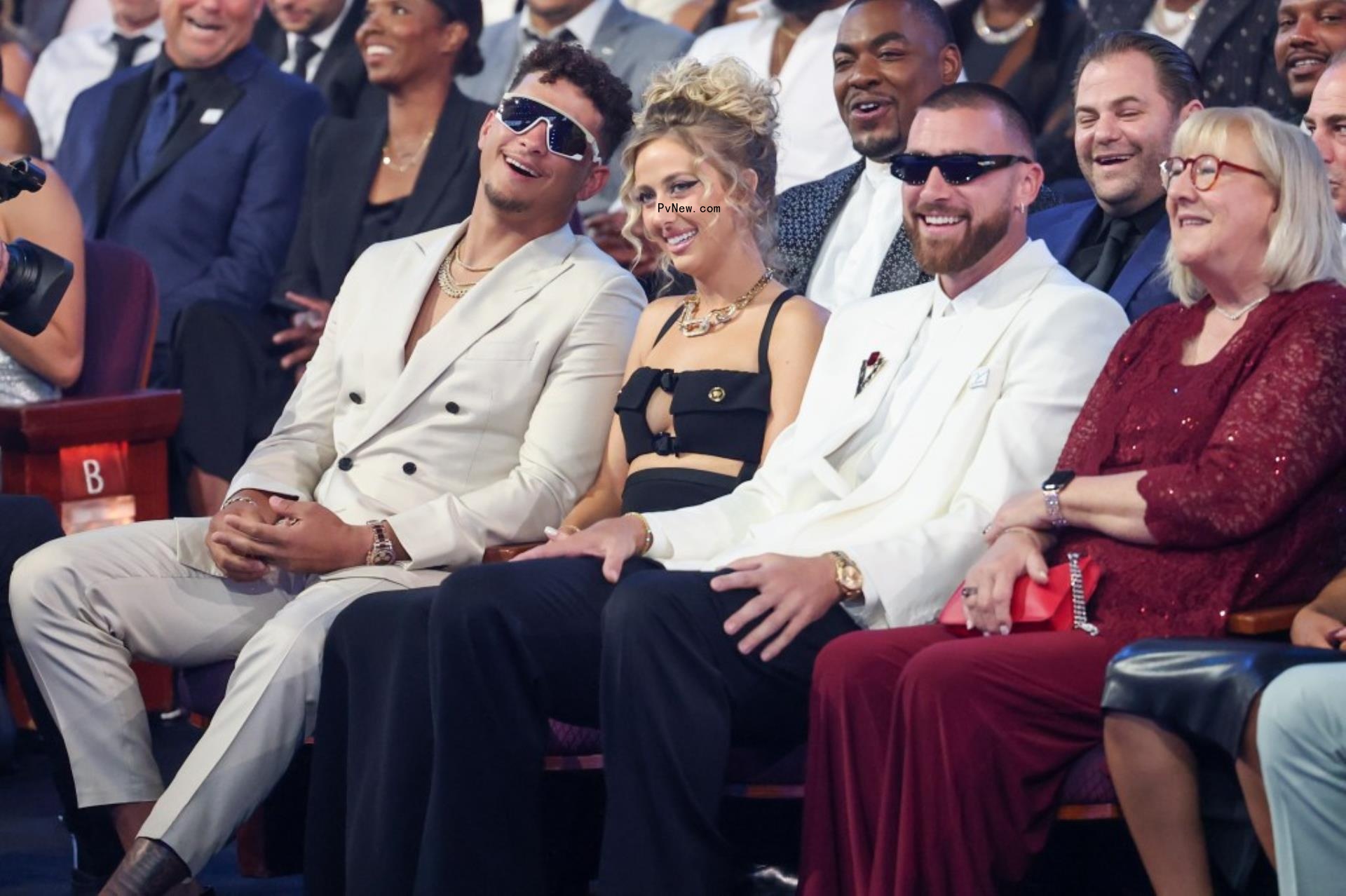Brittany Mahomes sitting in between Patrick Mahomes and Travis Kelce.