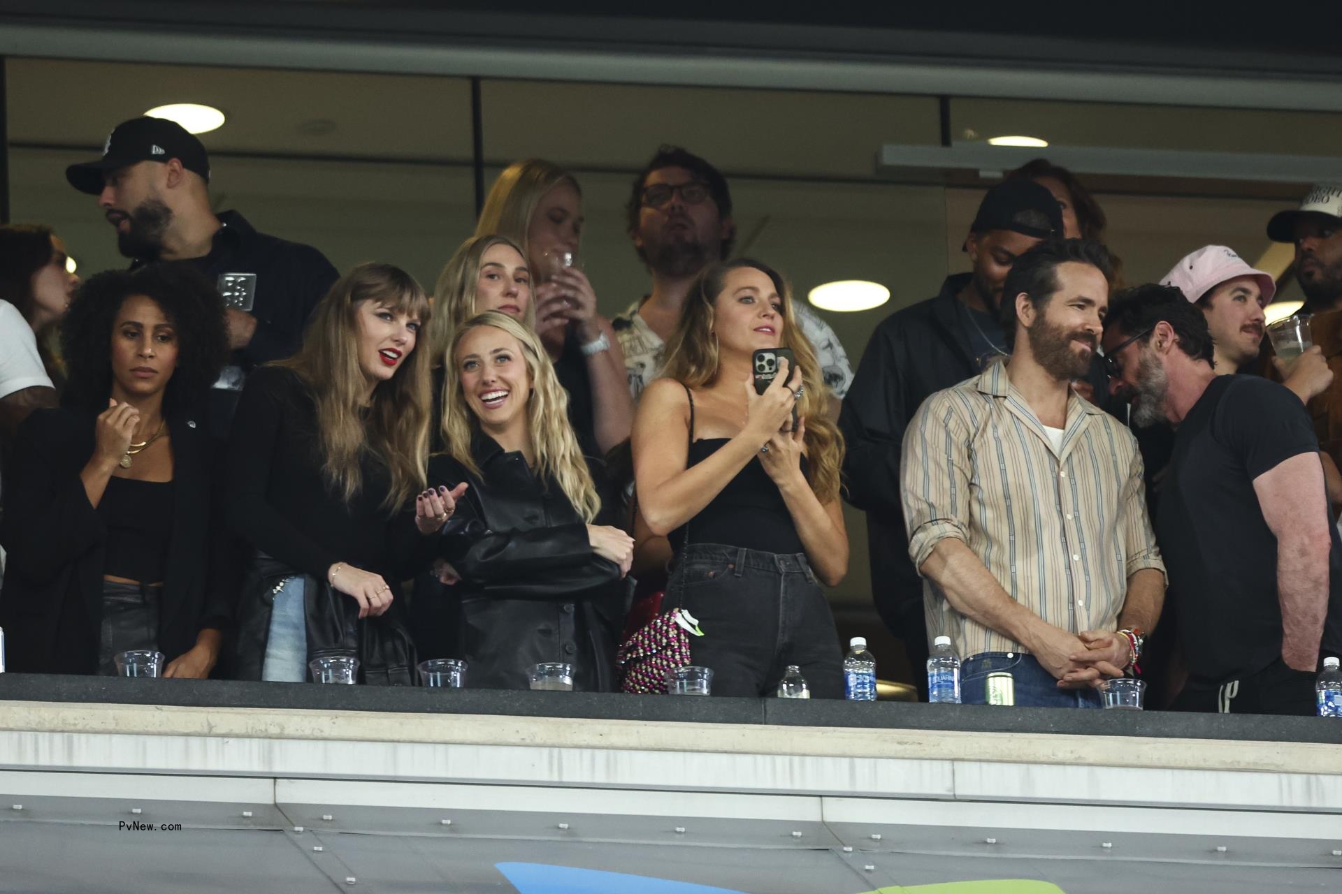 Brittany Mahomes, Taylor Swift, Blake Lively and others cheering during an NFL game.