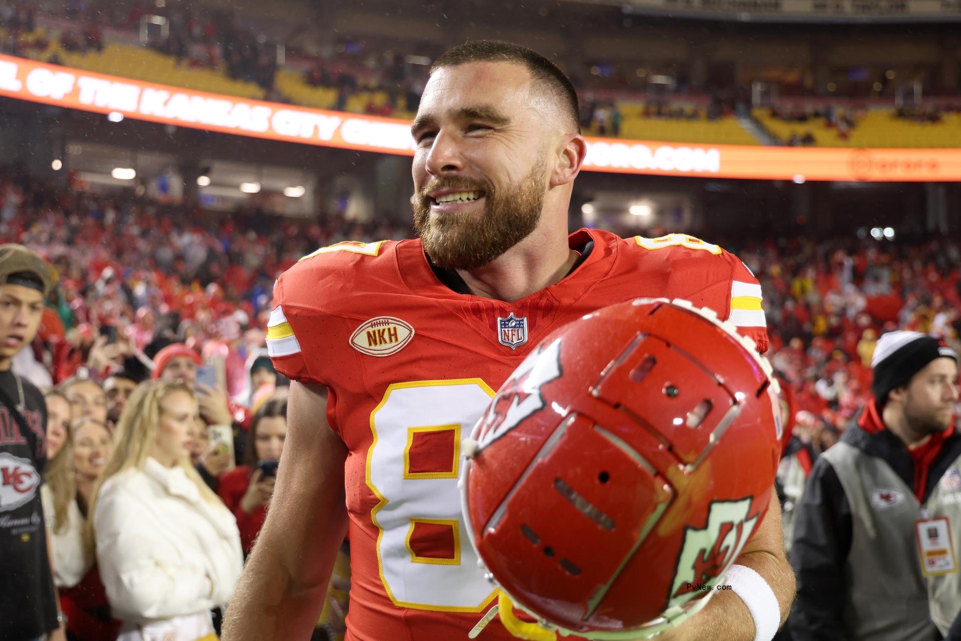Travis Kelce in uniform on the football field.