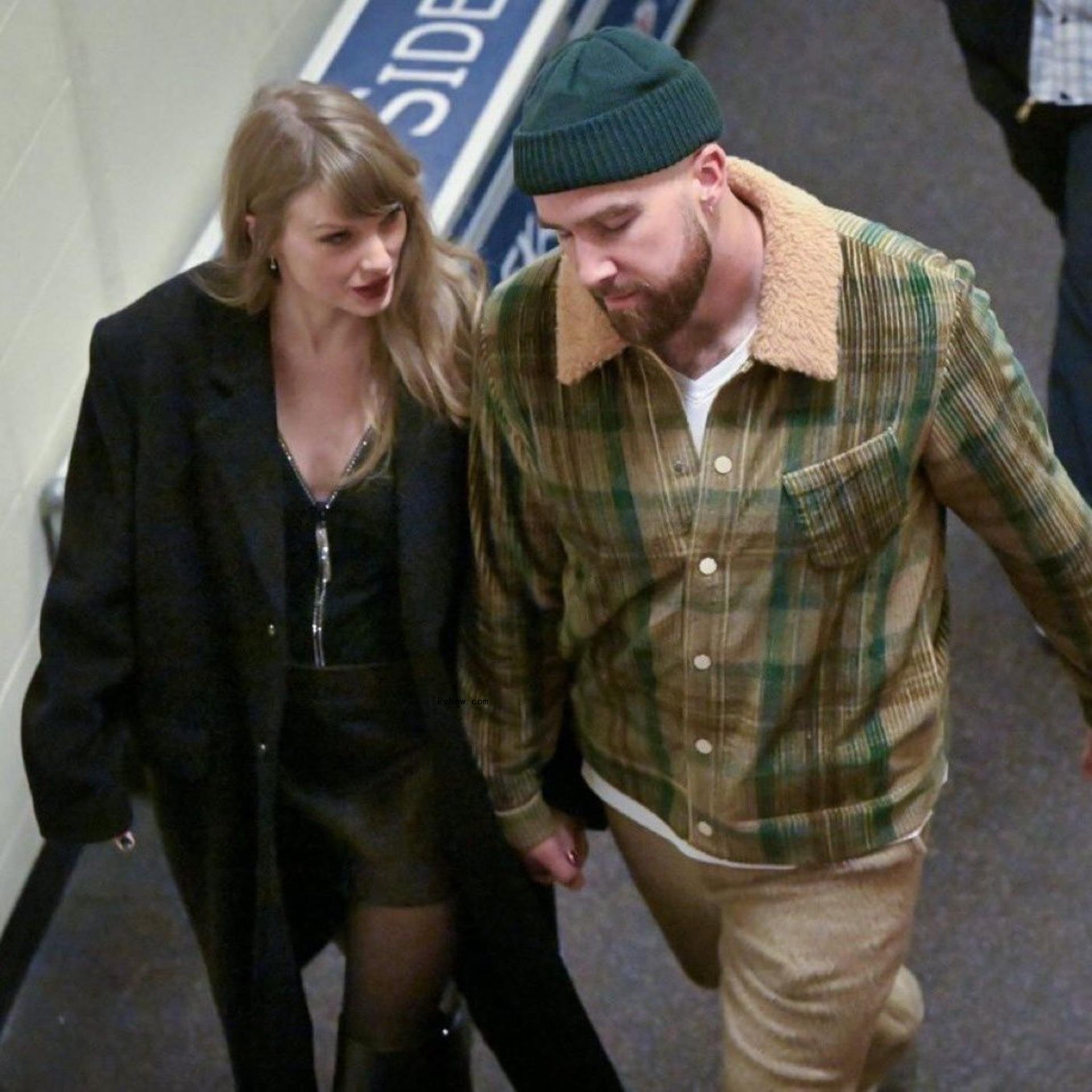 Taylor Swift and Travis Kelce holding hands.