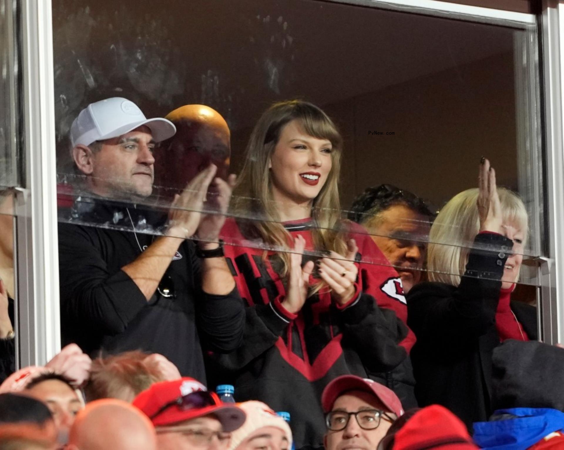 taylor swift wearing Chiefs merch and clapping