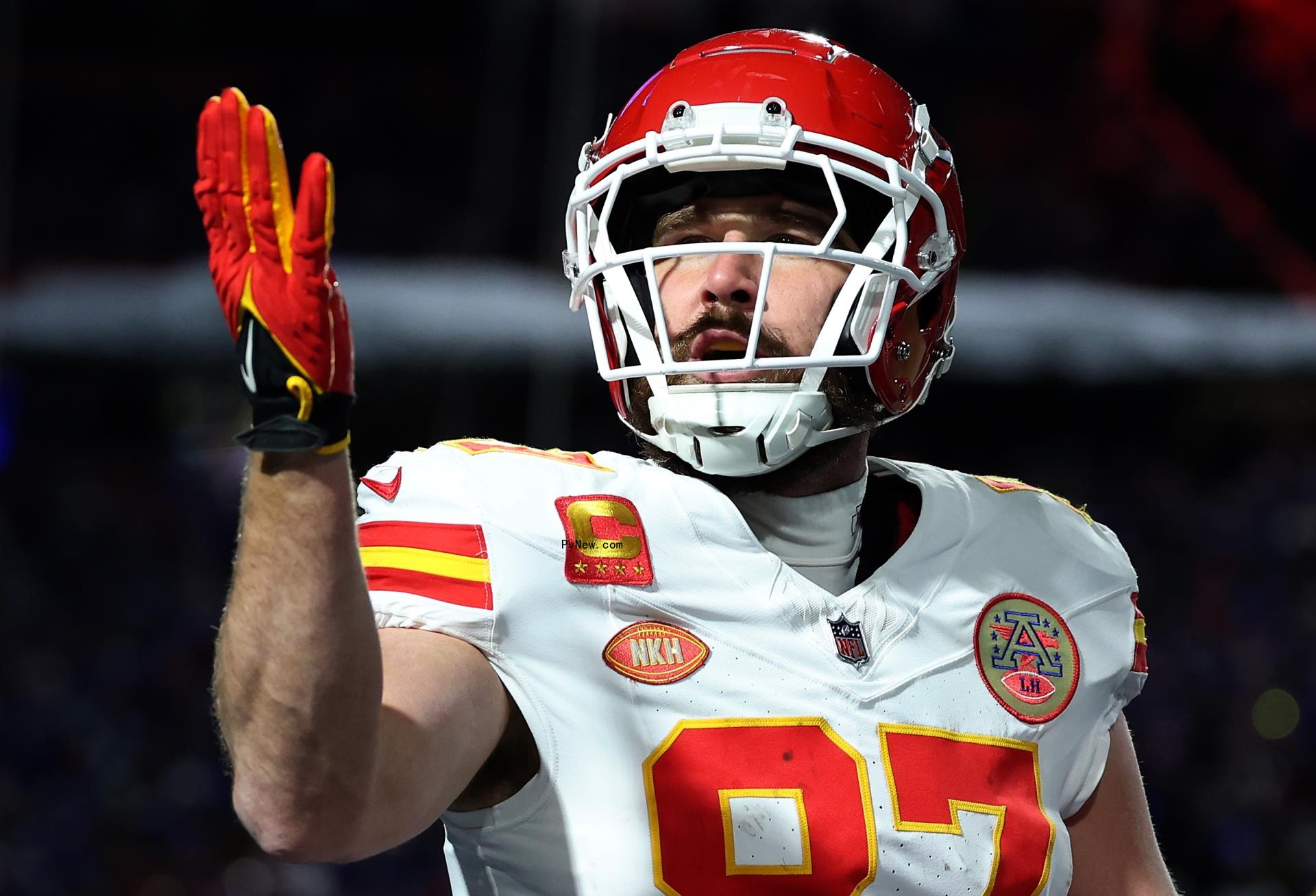 Travis Kelce blowing a kiss on the football field