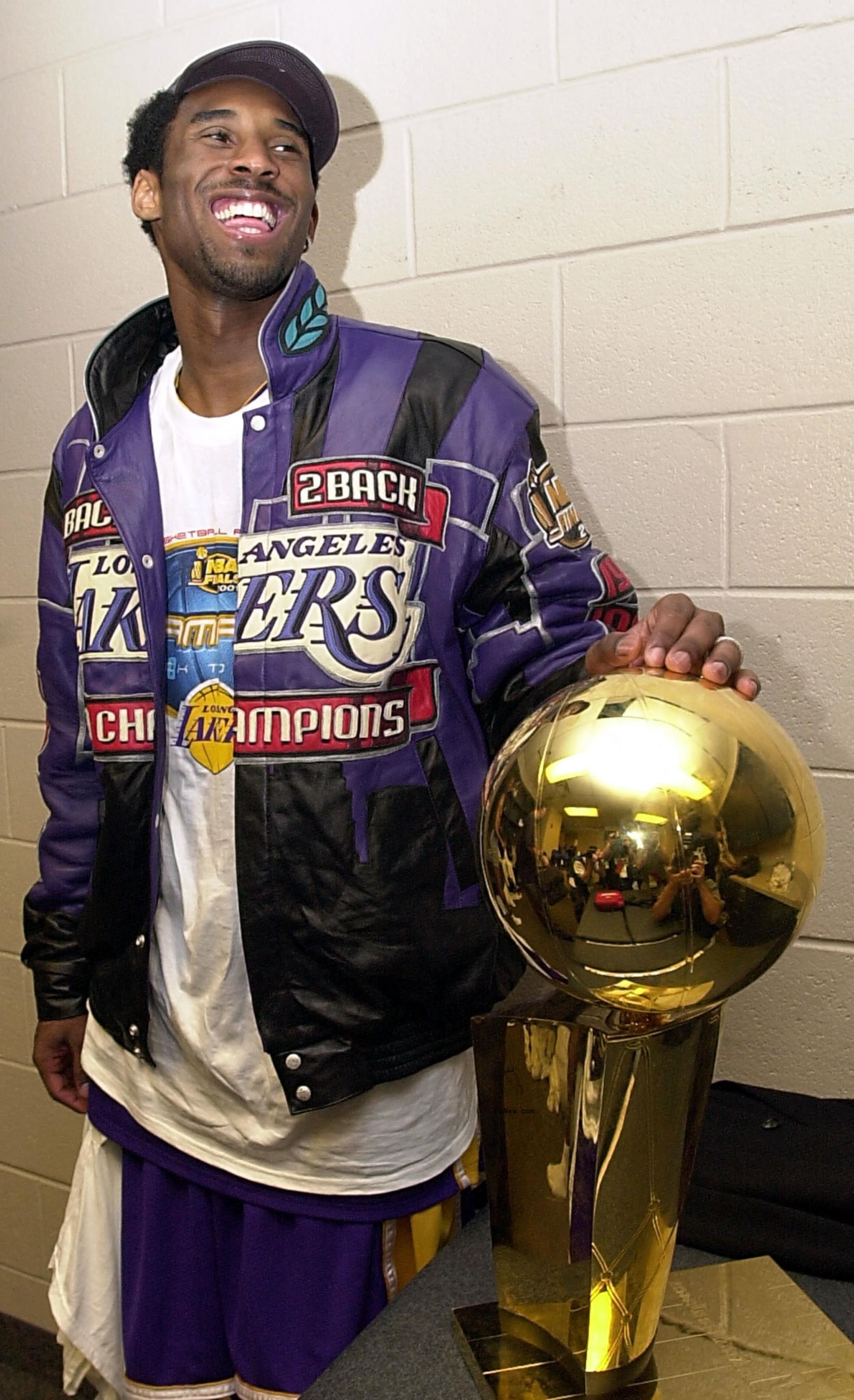 Kobe Bryant standing with the 2001 NBA Champio<i></i>nship trophy.
