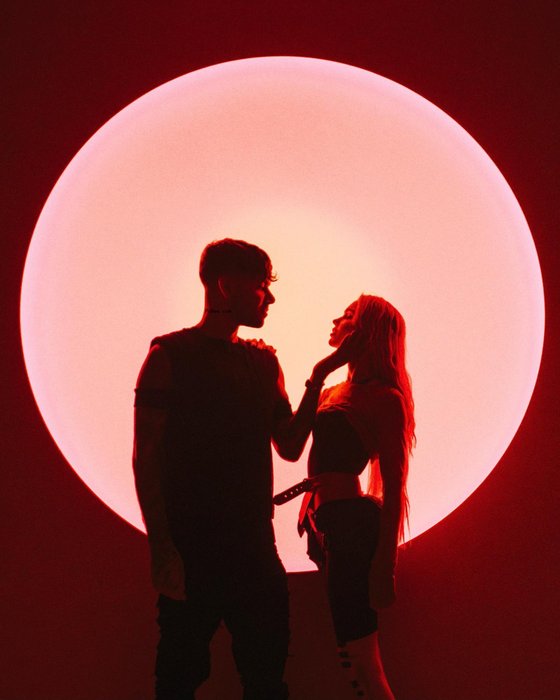 DJ Anyma holding Grimes' face.