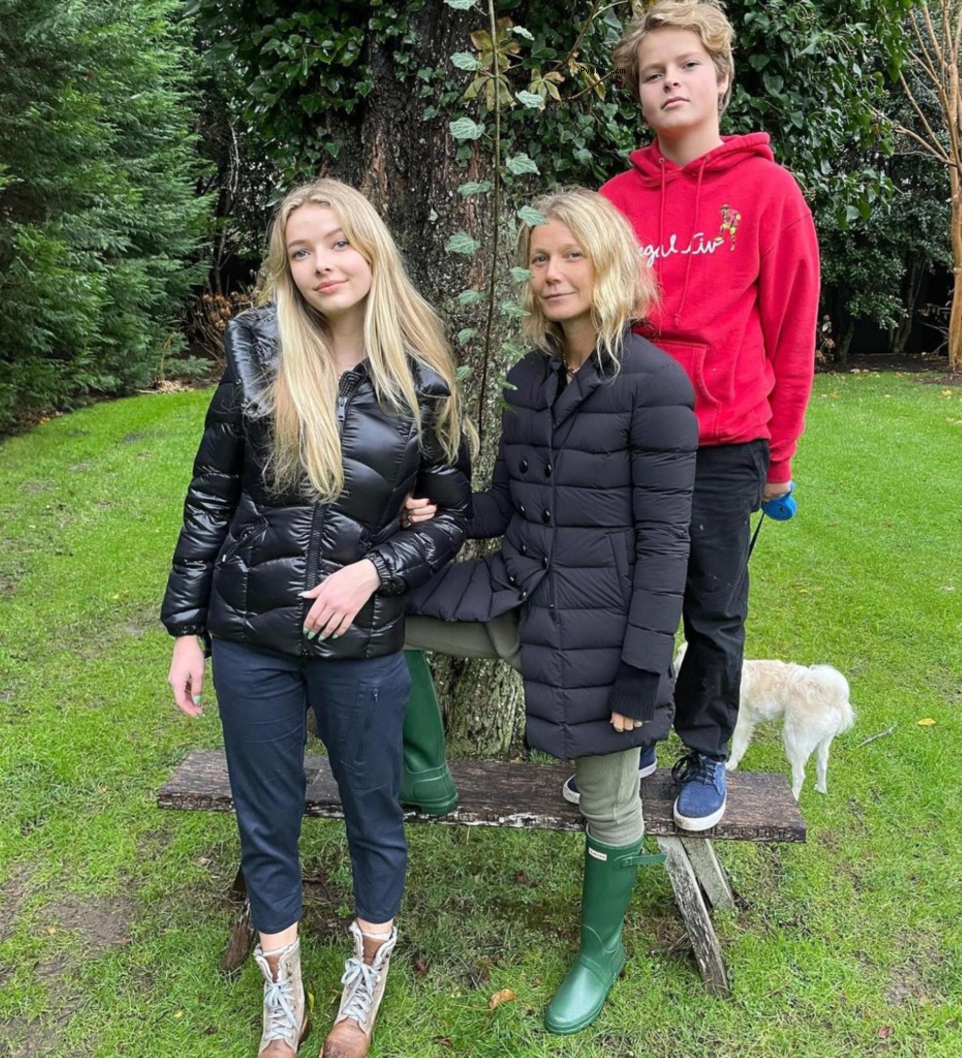 Gwyneth Paltrow with her children and dog in yard. 