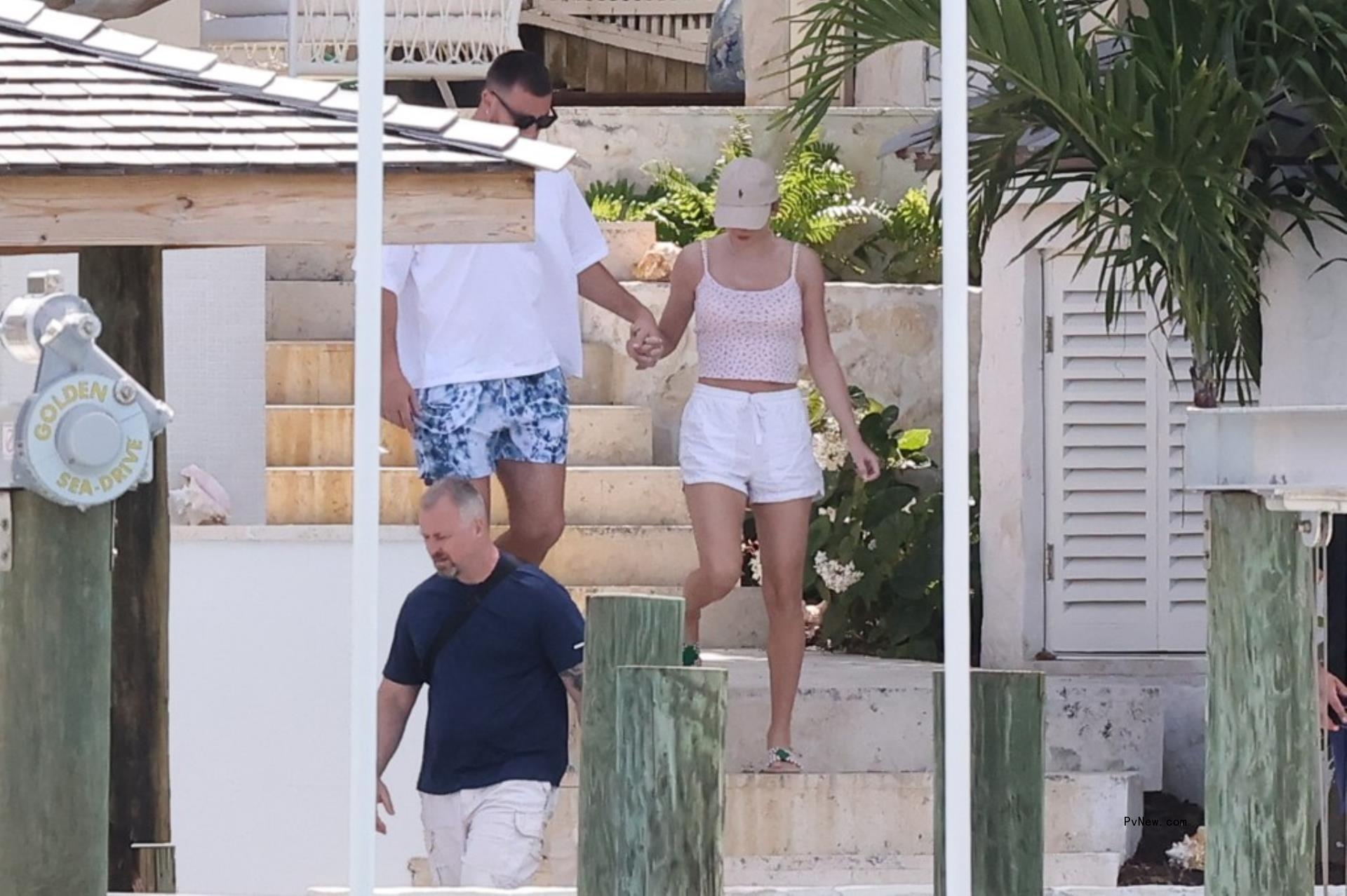 Travis Kelce and Taylor Swift holding hands in the Bahamas.