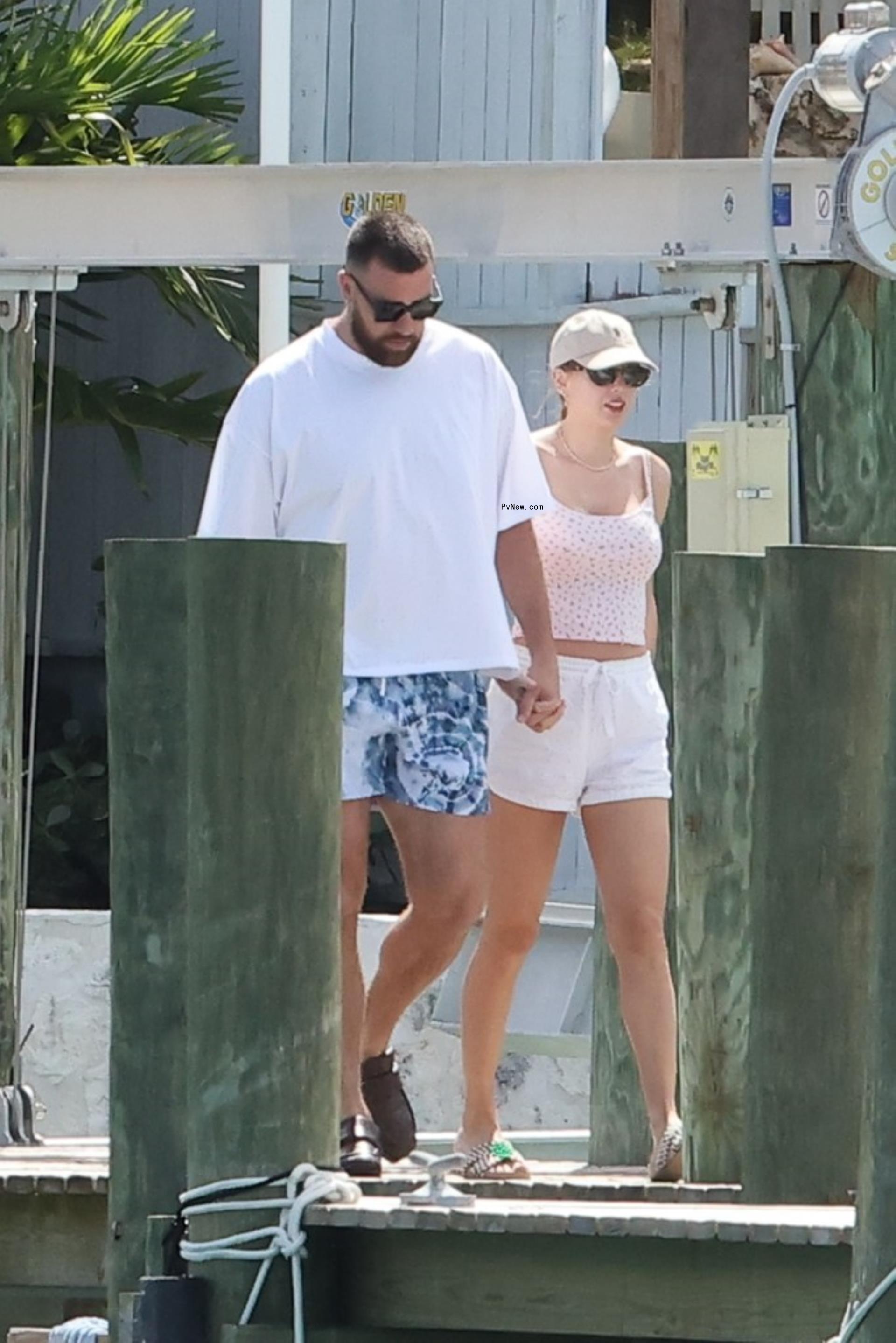 Travis Kelce and Taylor Swift holding hands in the Bahamas.