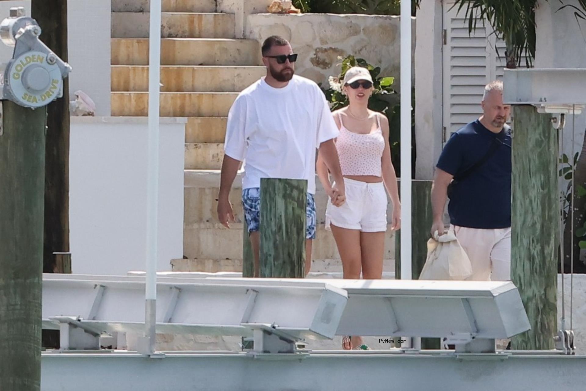 Travis Kelce and Taylor Swift holding hands in the Bahamas.
