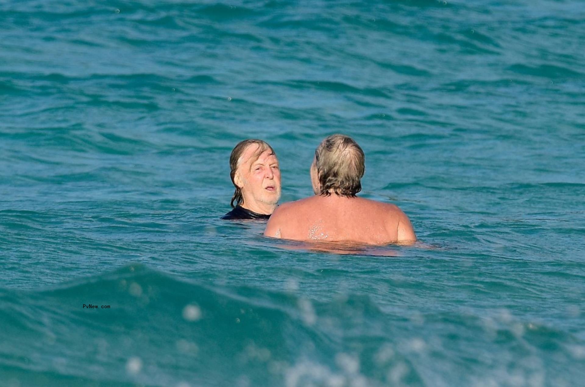 Paul McCartney and a friend swimming in St. Barts