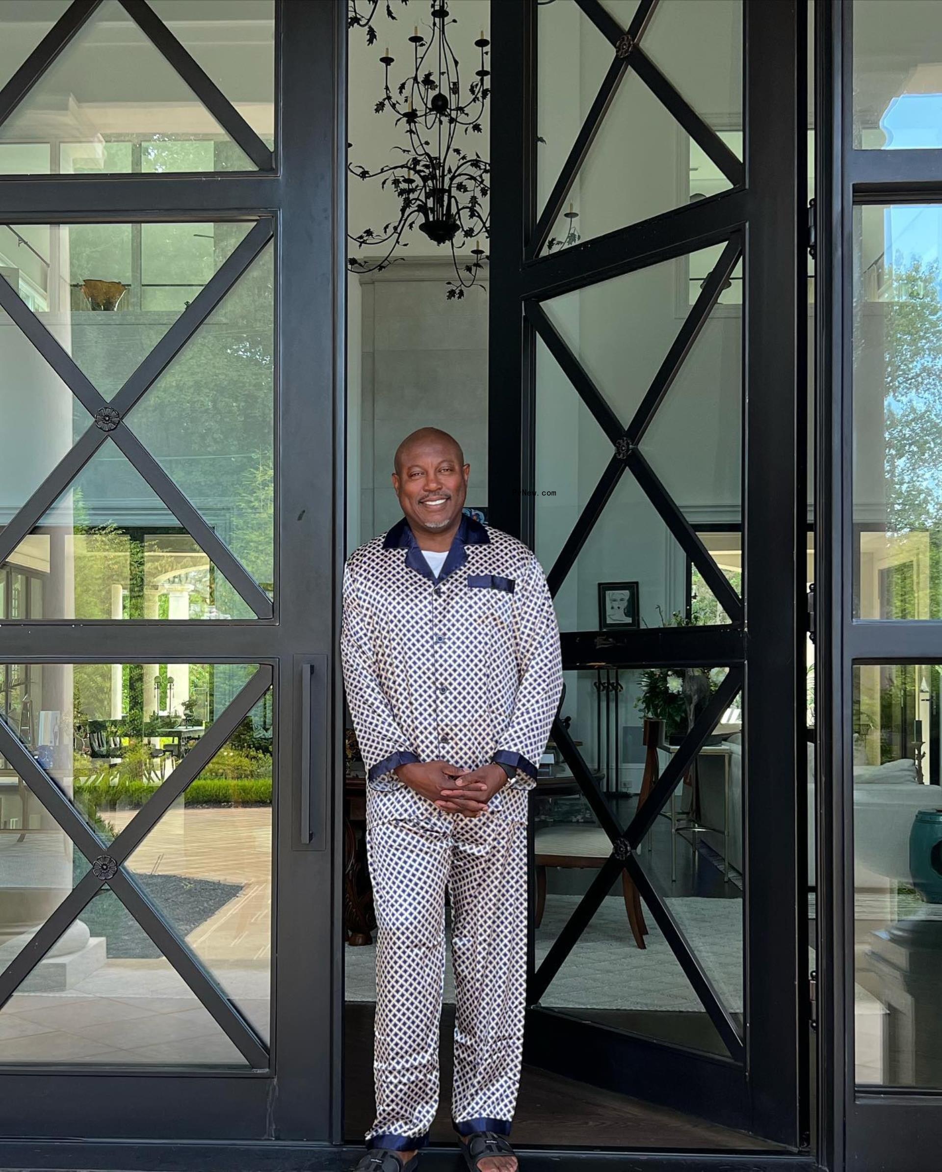 simon guobadia standing among a glass door