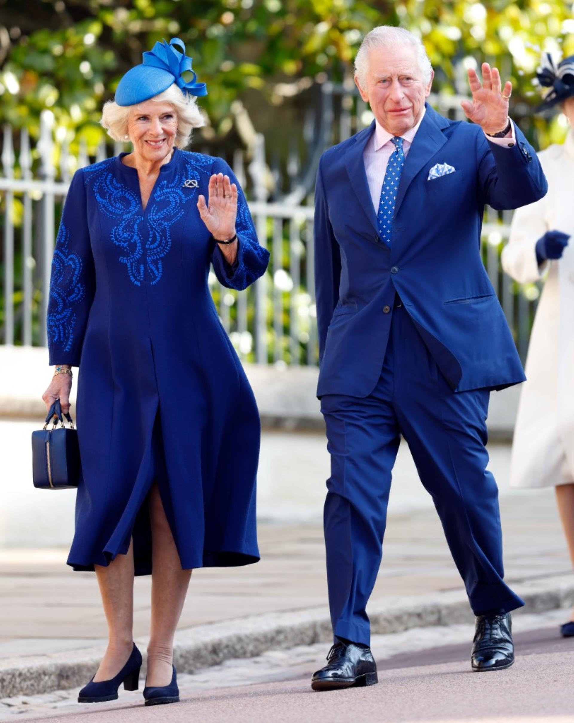 King Charles and Queen Camilla smiling and waving