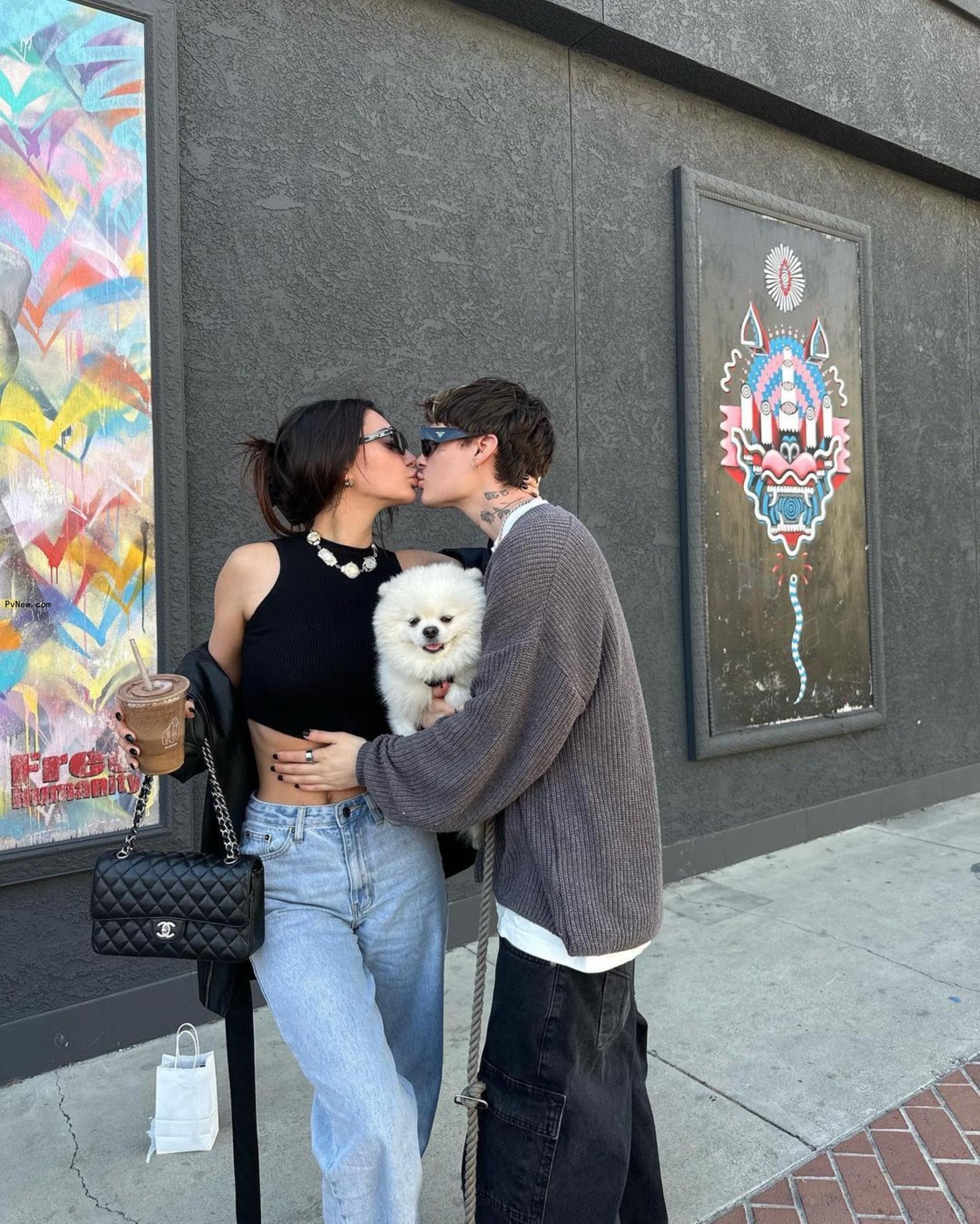 francesca farago and jesse sullivan kissing while holding a dog