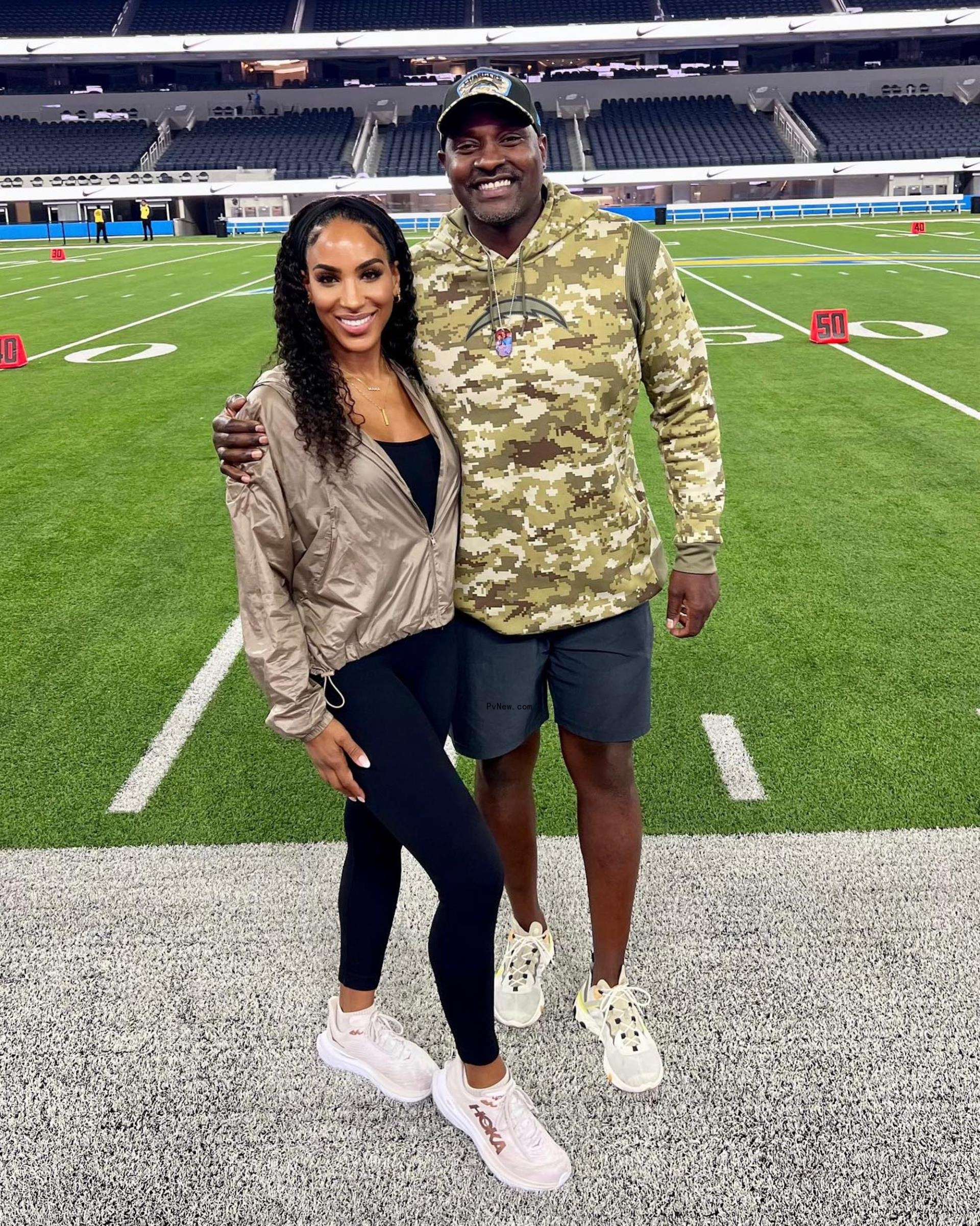 Marcellus Wiley and Annemarie Wiley on the football field.