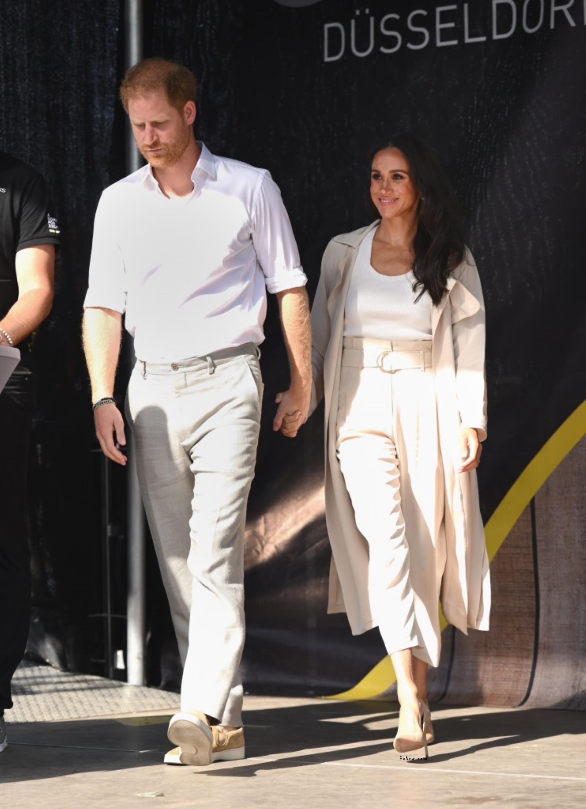 Prince Harry and Meghan Markle holding hands. 