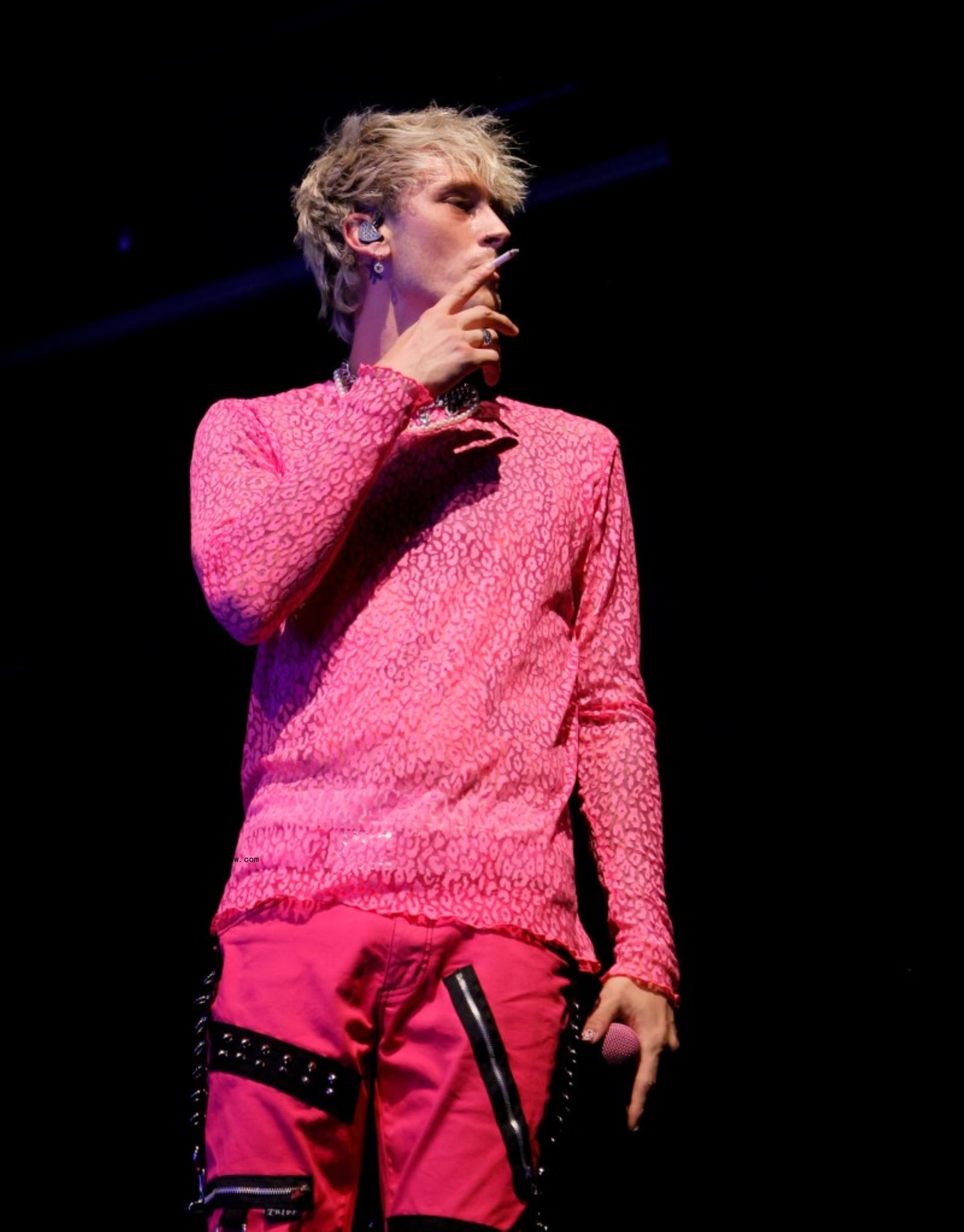Machine Gun Kelly smoking on stage. 