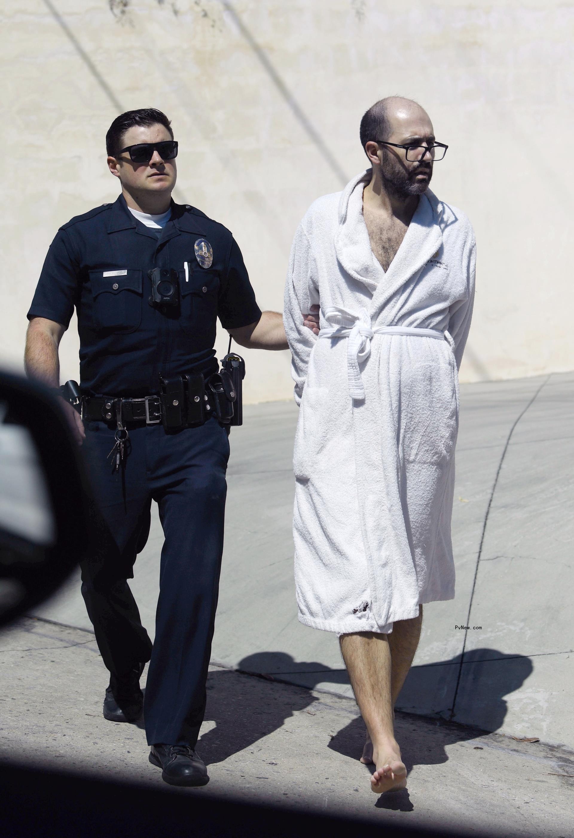 Christian Richard being arrested in a robe.