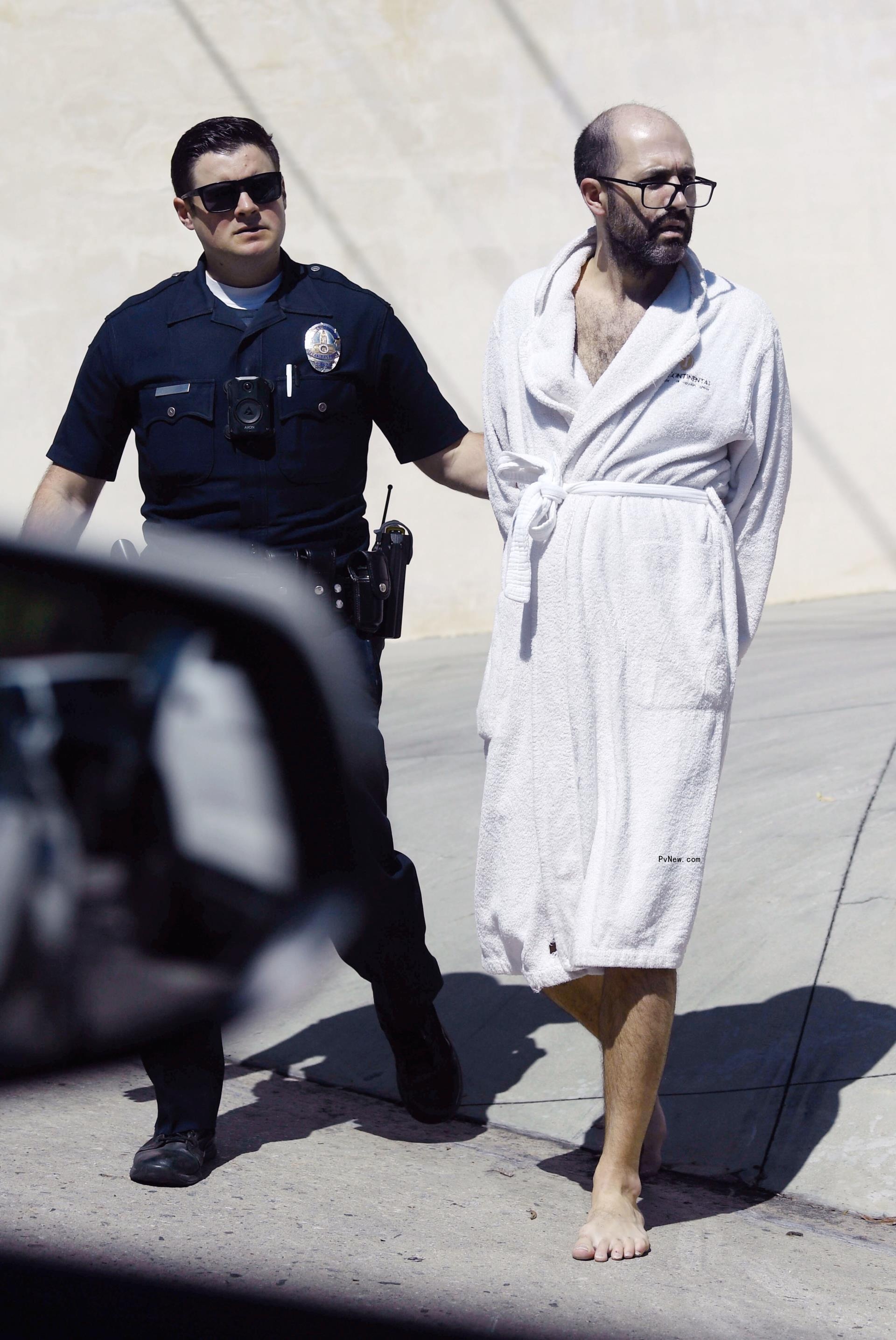 Christian Richard being arrested in a robe.