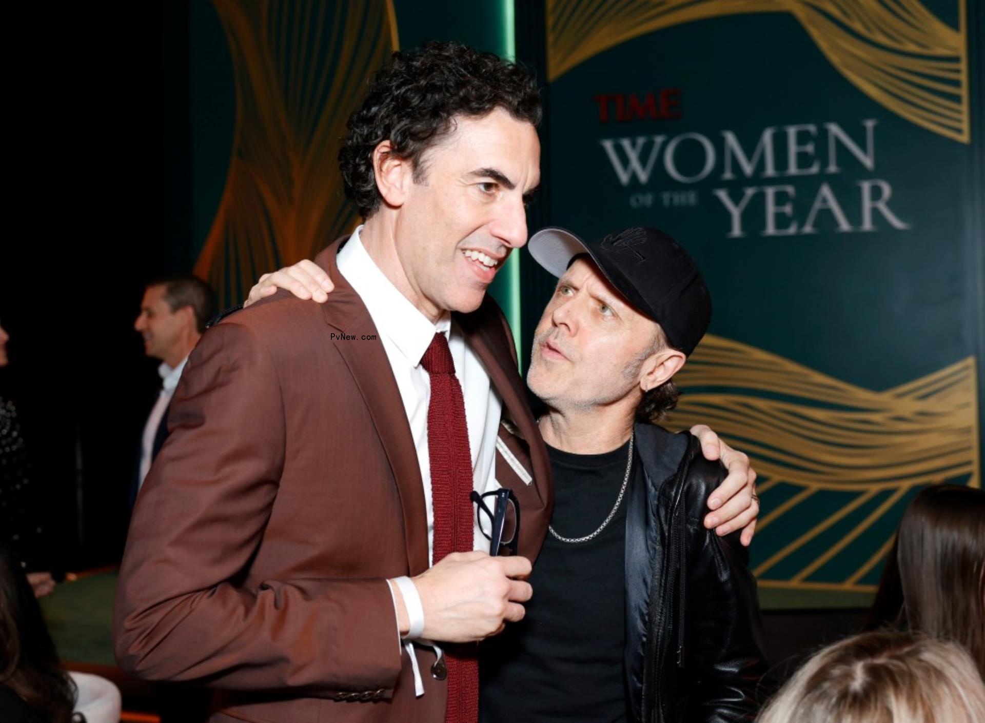 Sacha Baron Cohen puts his arm around Lars Ulrich.