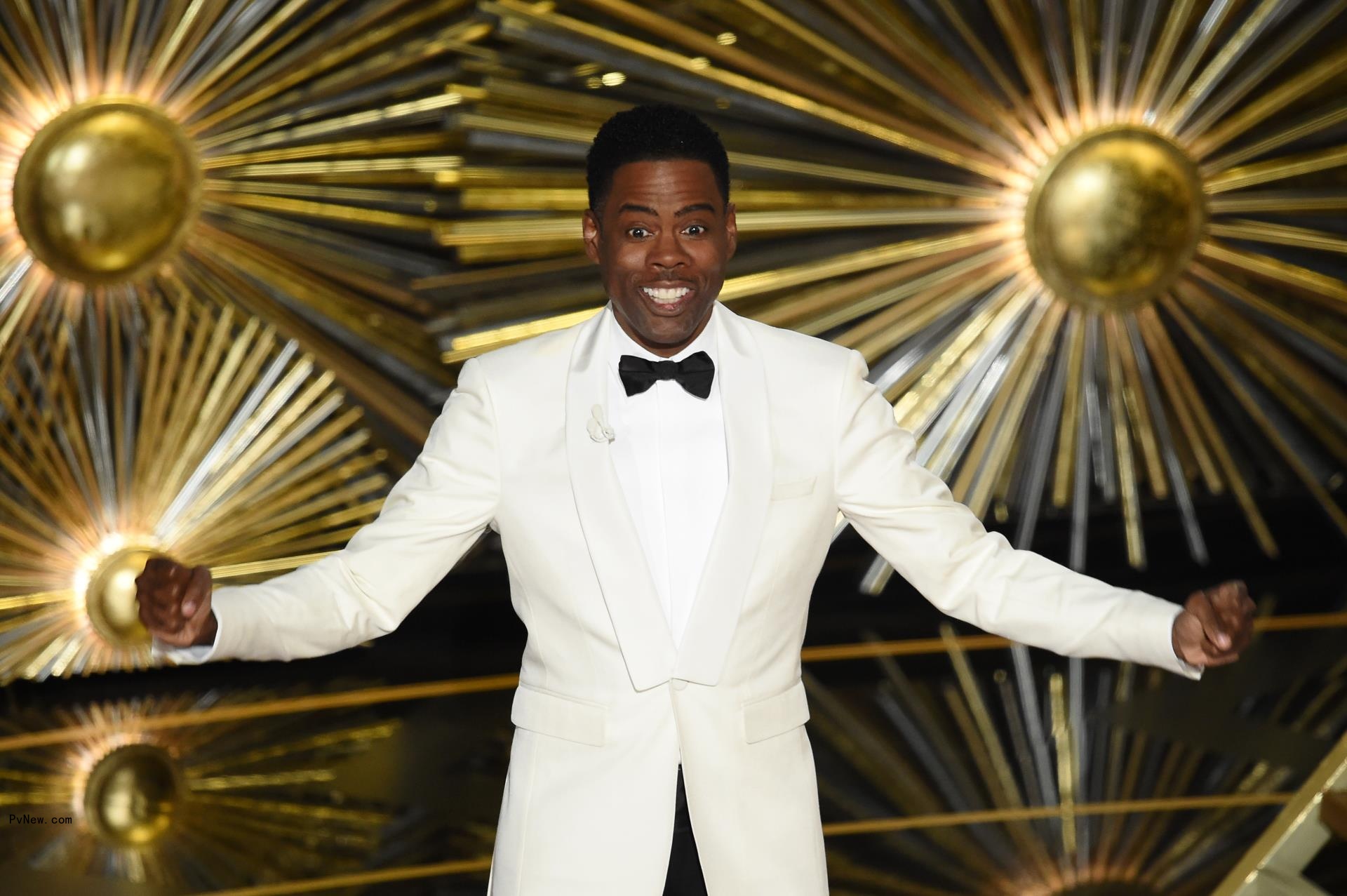 chris rock with his arm stretched wide