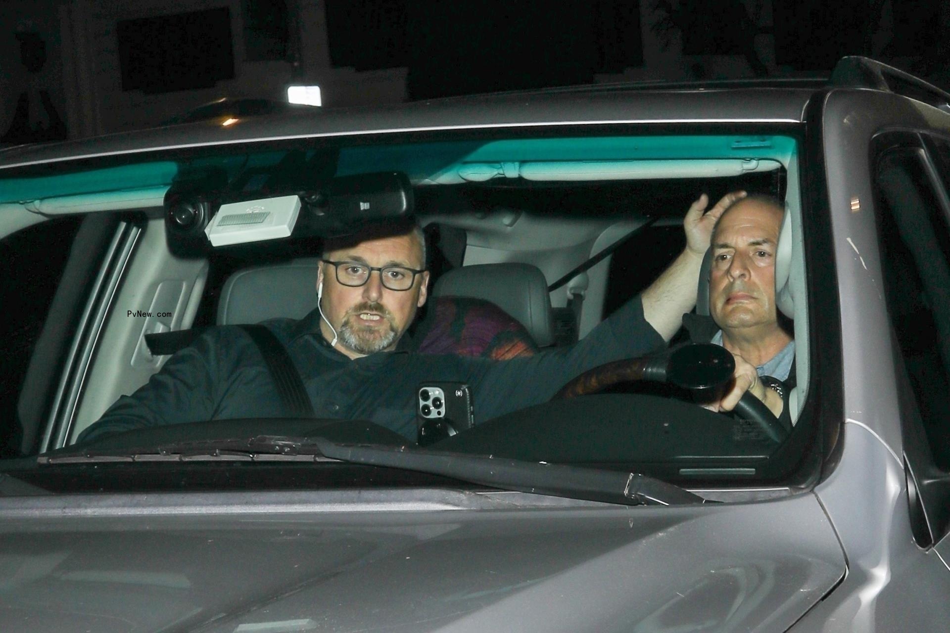 Taylor Swift and Travis Kelce hiding in a car.